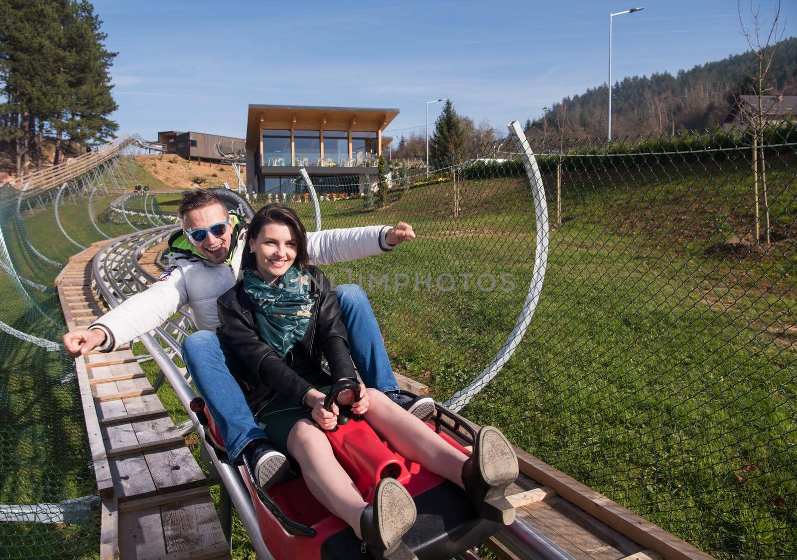 couple enjoys driving on alpine coaster by dotshock
