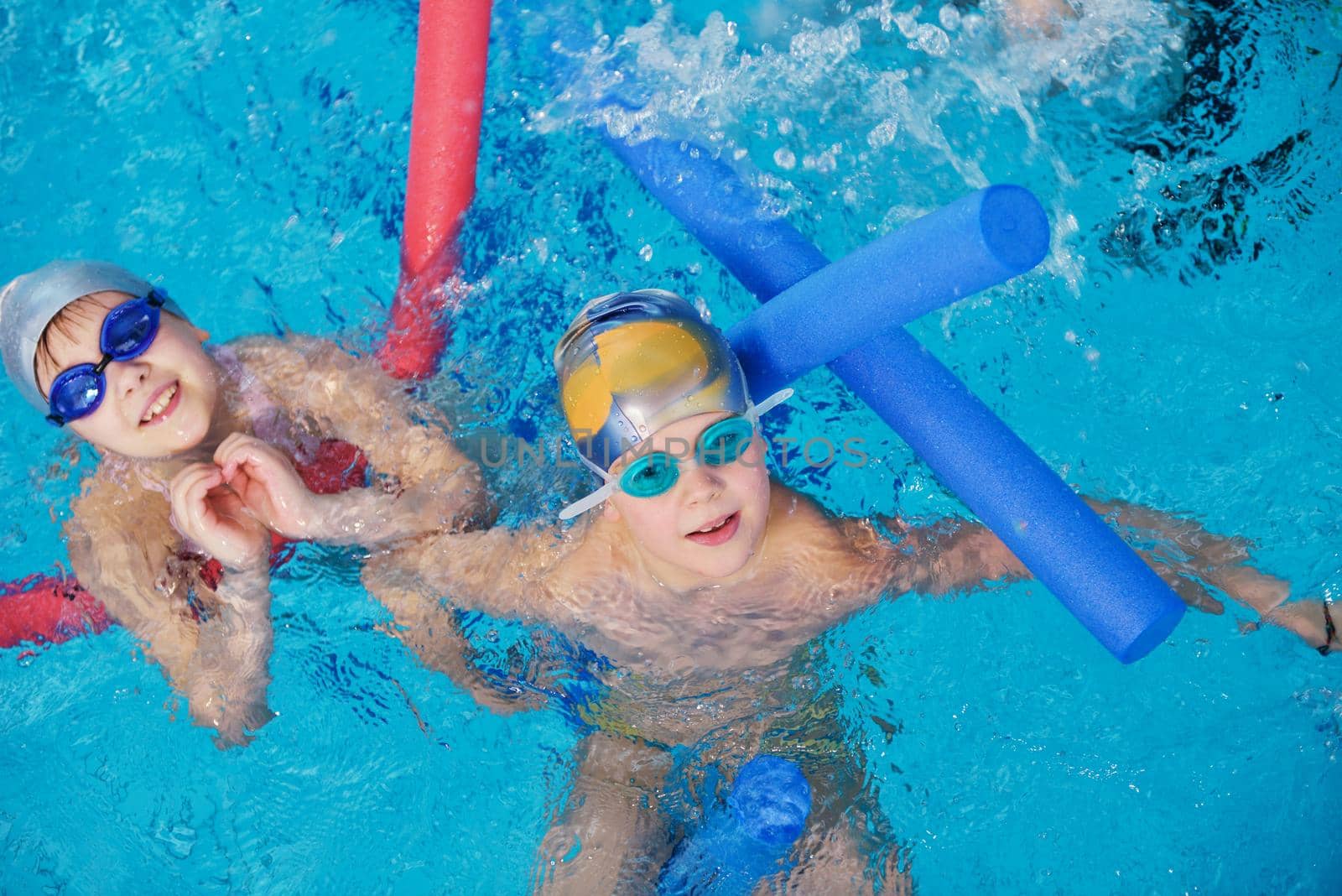 happy children kids group  at swimming pool class  learning to swim