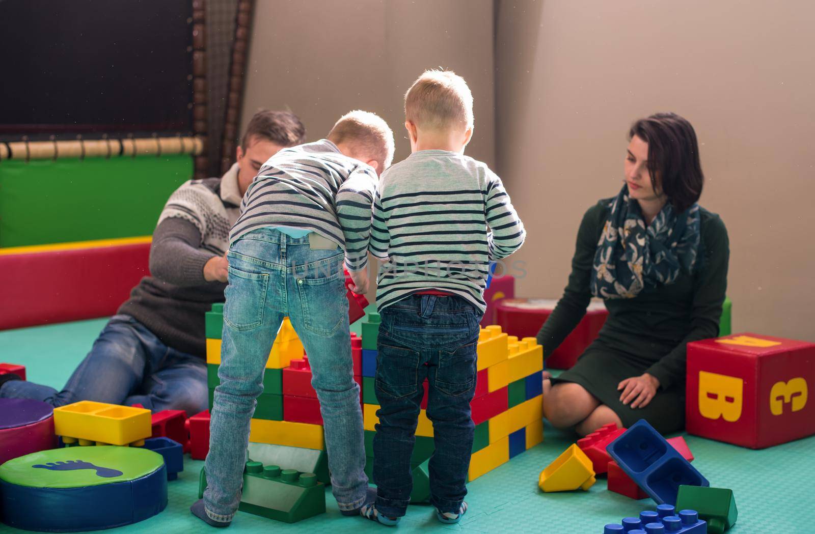 happy family enjoying free time young parents and kids having fun while playing together at childrens playroom