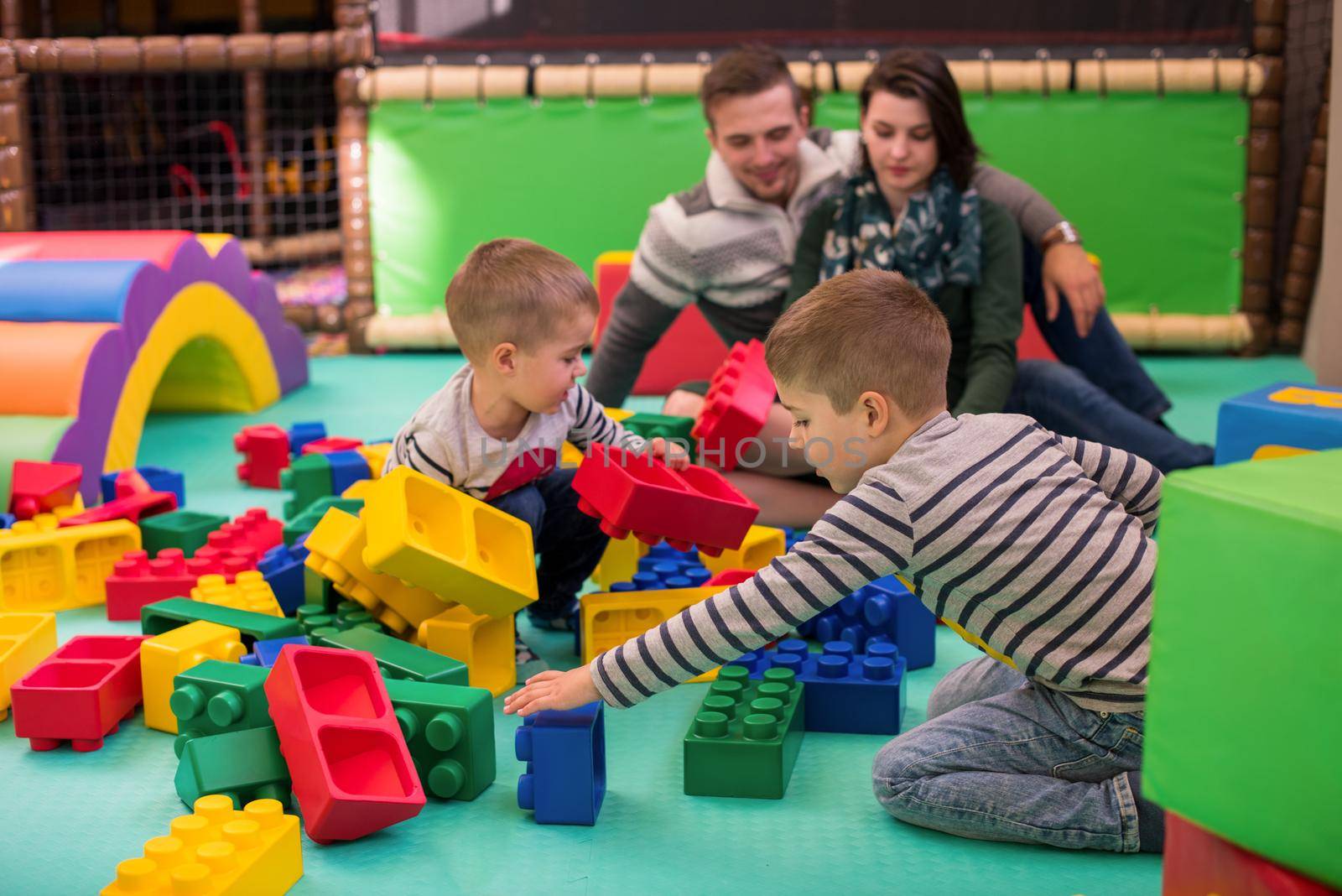 happy family enjoying free time young parents and kids having fun while playing together at childrens playroom