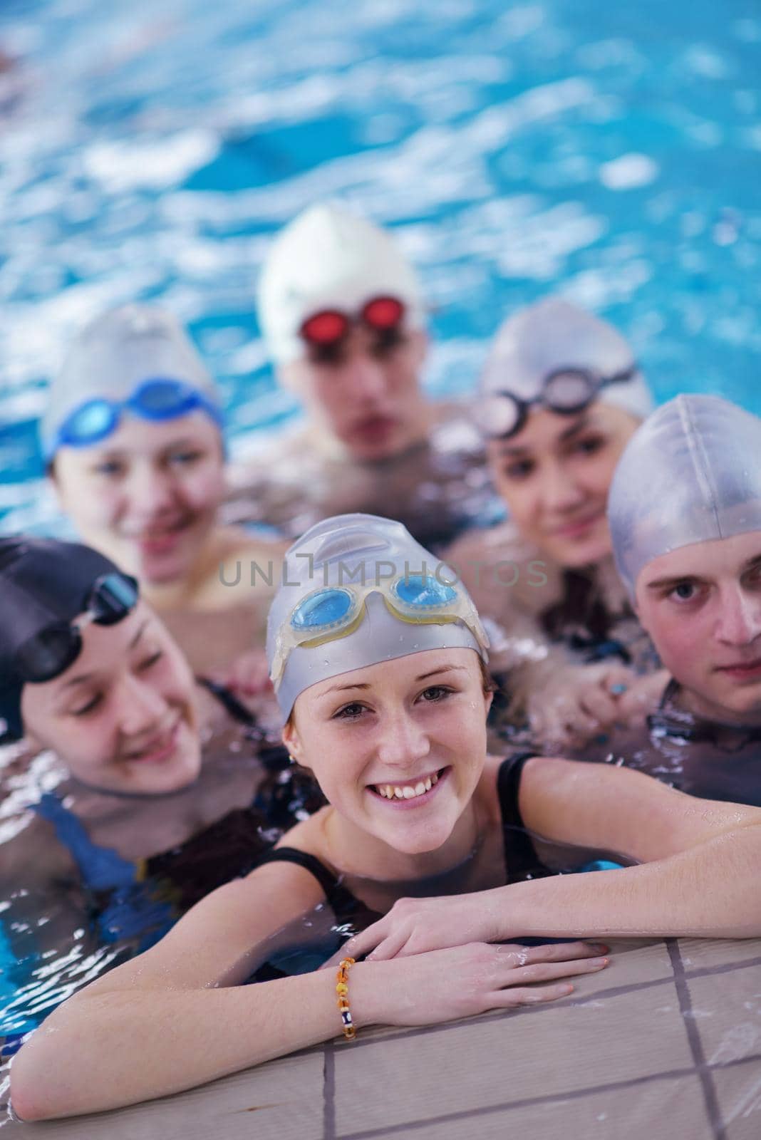 happy teen  group  at swimming pool class  learning to swim and have fun