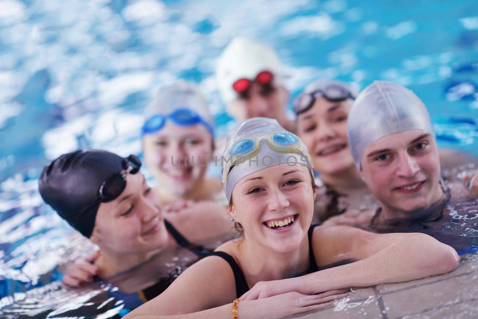 happy teen group  at swimming pool by dotshock