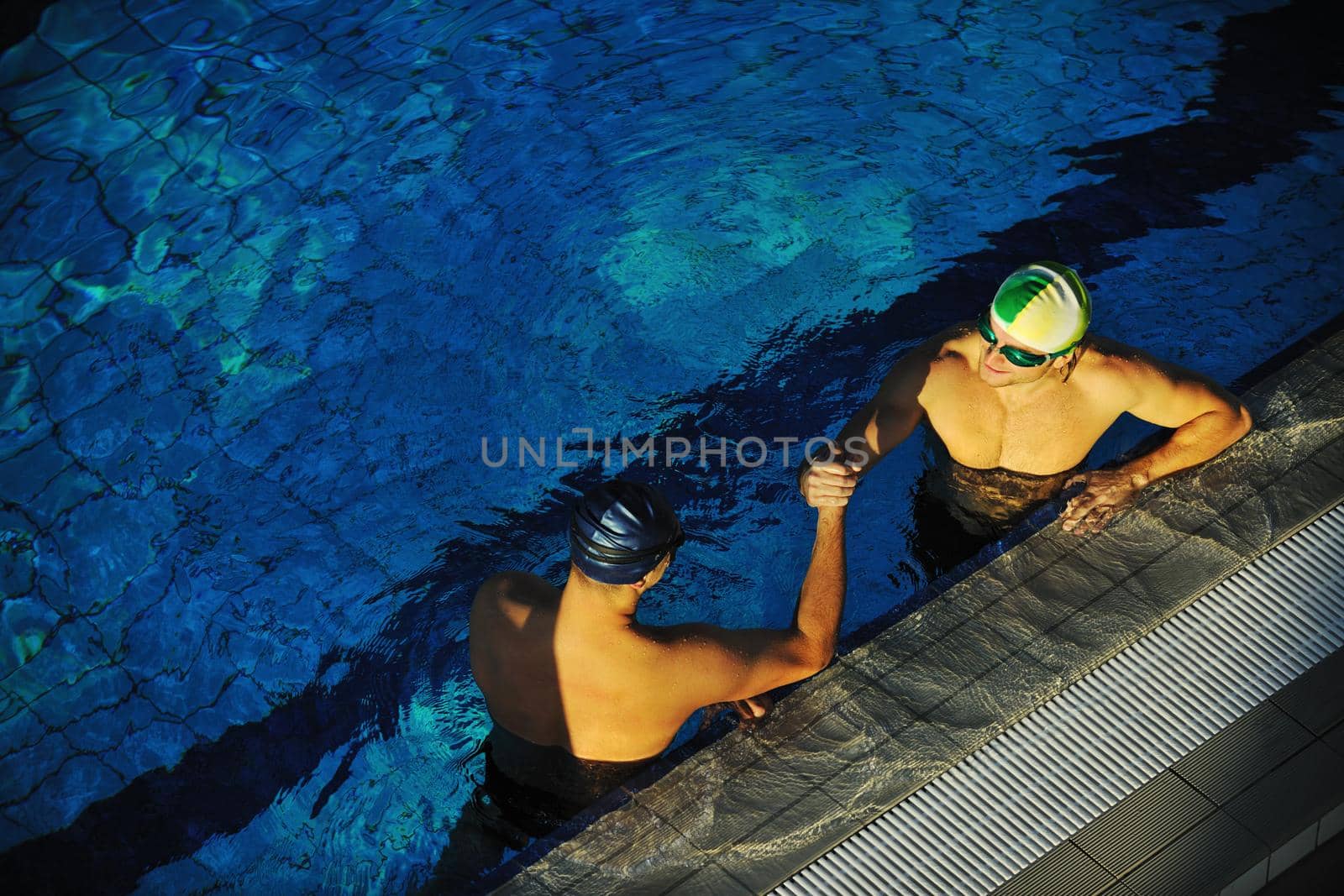 win competiotion and swimming race concept with two freiend who handshaking in pool