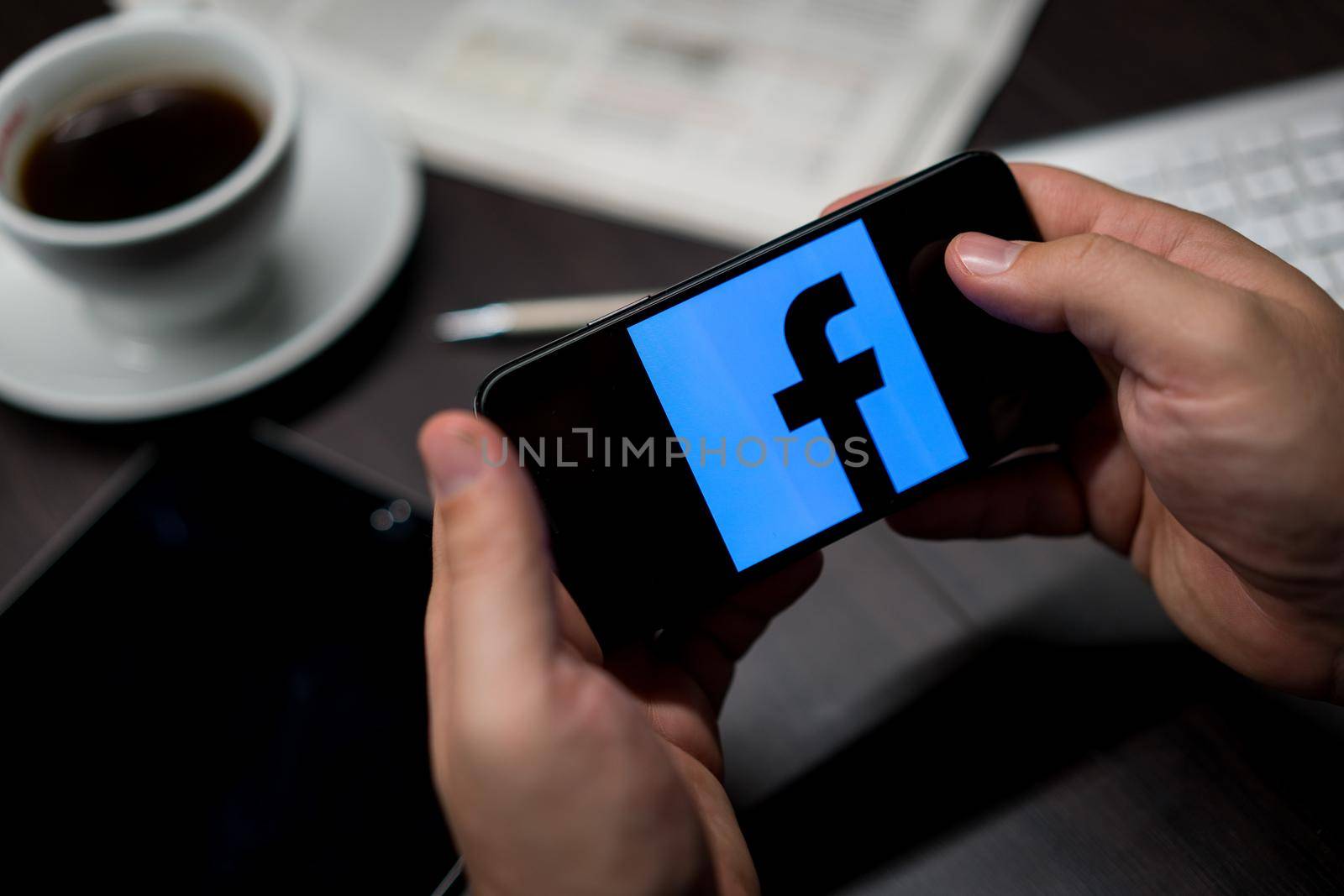 New York, New York / USA - 11 11 2019: Logo of Facebook on the iPhone X in hands in office