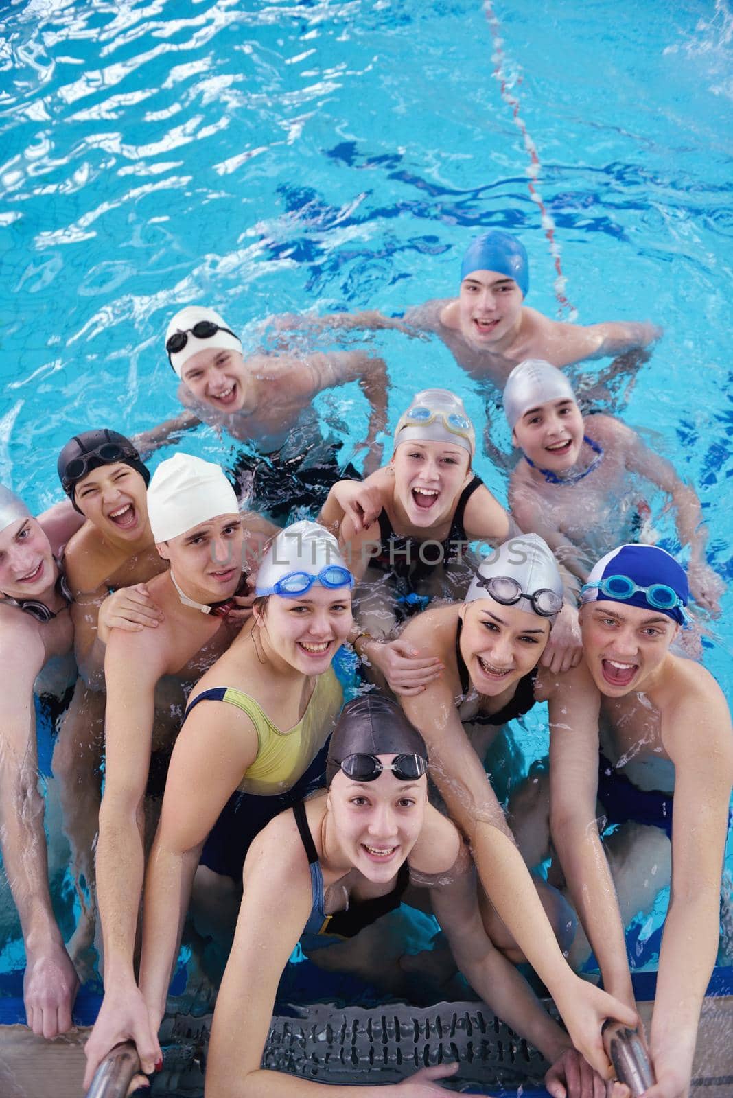 happy teen  group  at swimming pool class  learning to swim and have fun