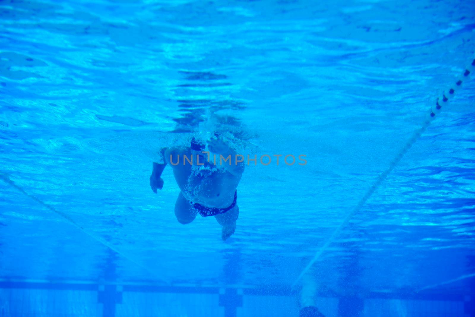 undervater shoot of swimming pool with good looking young swimmer 