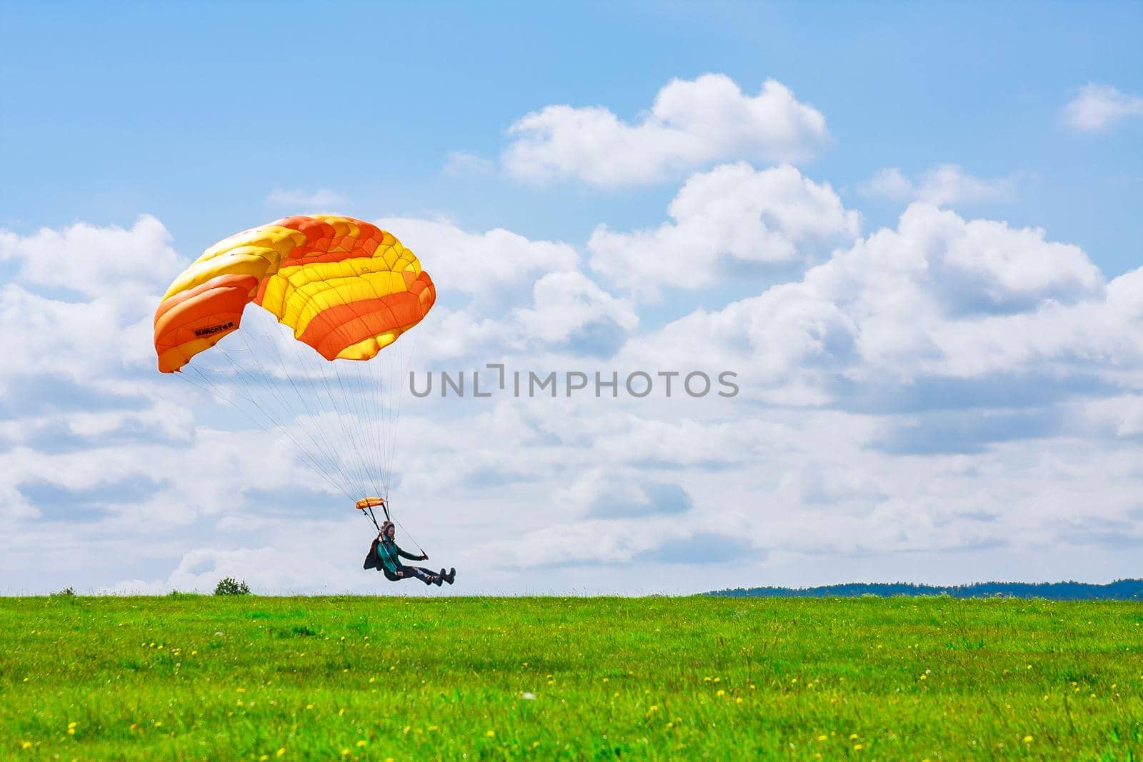 Skutech, Czech Republic, 6 August 2020: Landing of a parachutist on a grassy field. Parachute jumping. Skydiving.