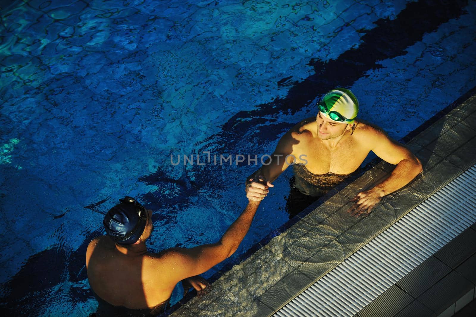 win competiotion and swimming race concept with two freiend who handshaking in pool