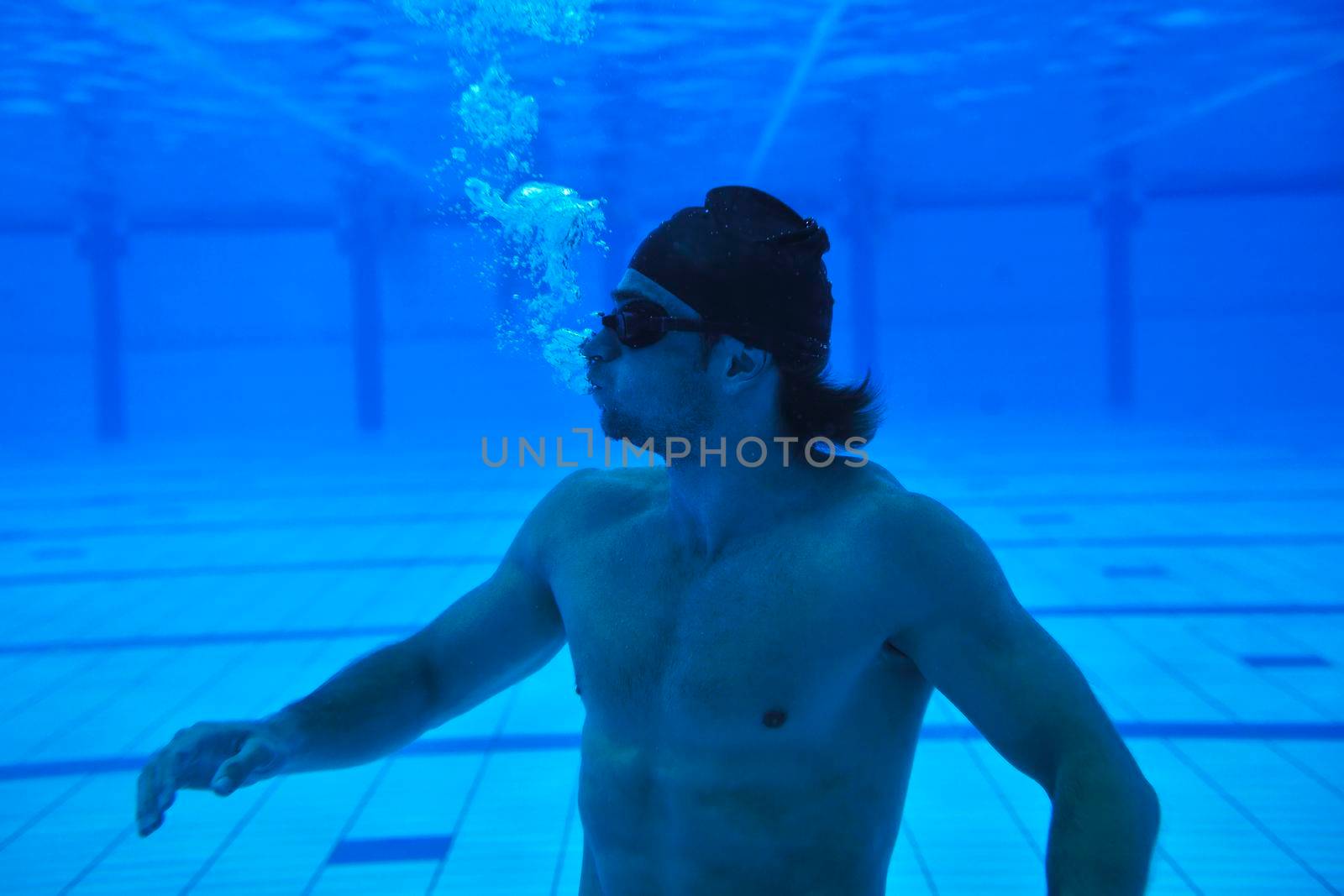 undervater shoot of swimming pool with good looking young swimmer 