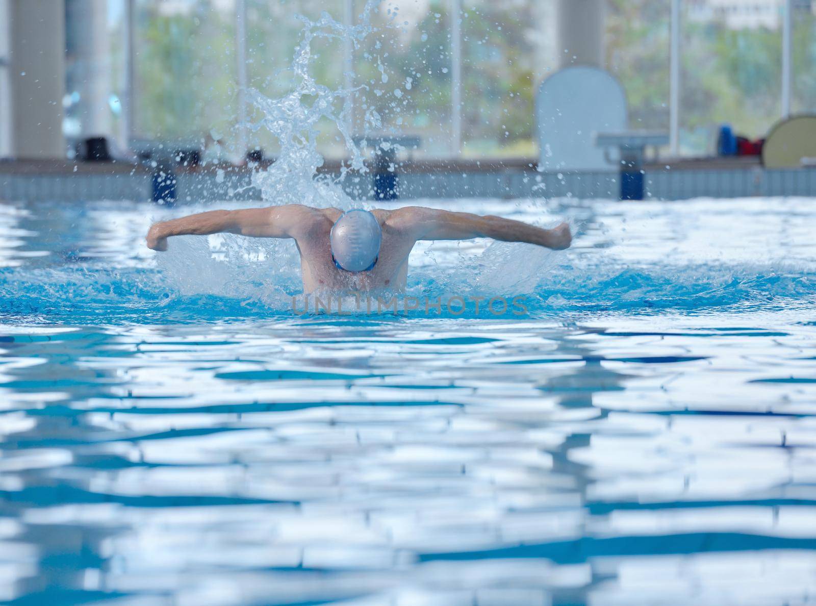 health and fitness lifestyle concept with young athlete swimmer recreating  on indoor olimpic pool