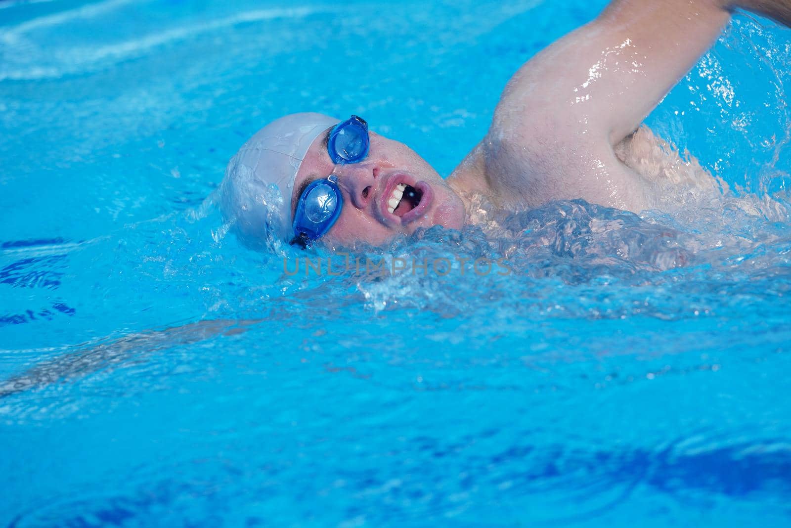 group of happy kids children   at swimming pool class  learning to swim