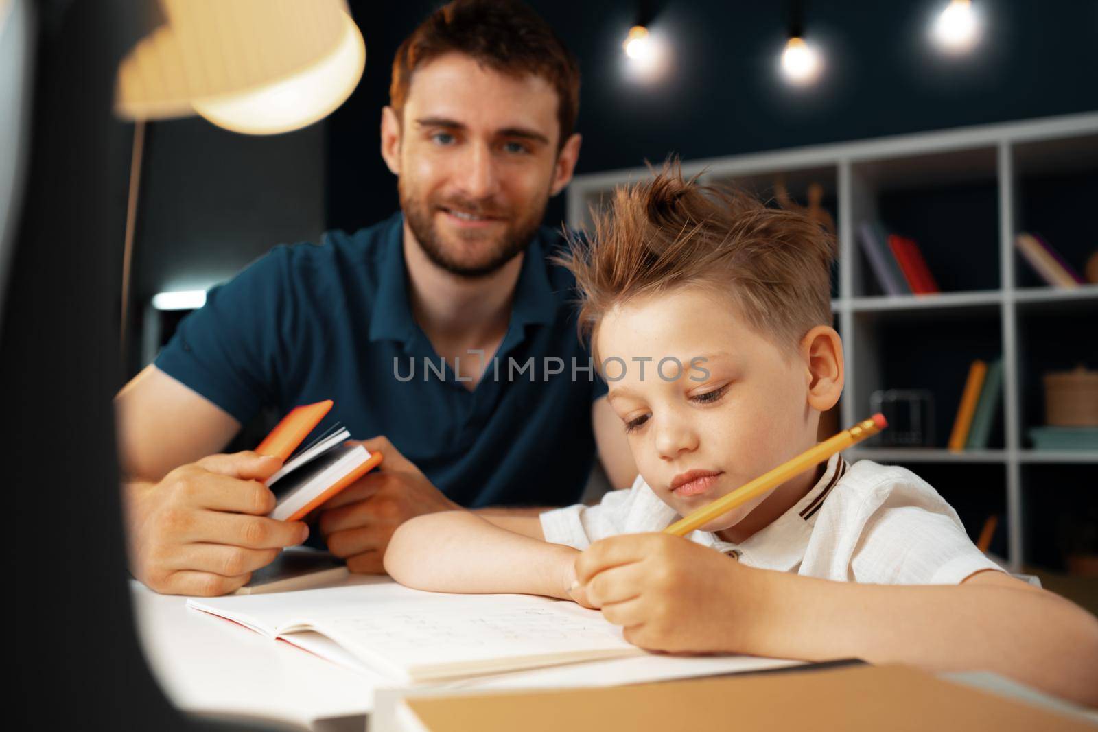 Father helping his little son with school homework close up