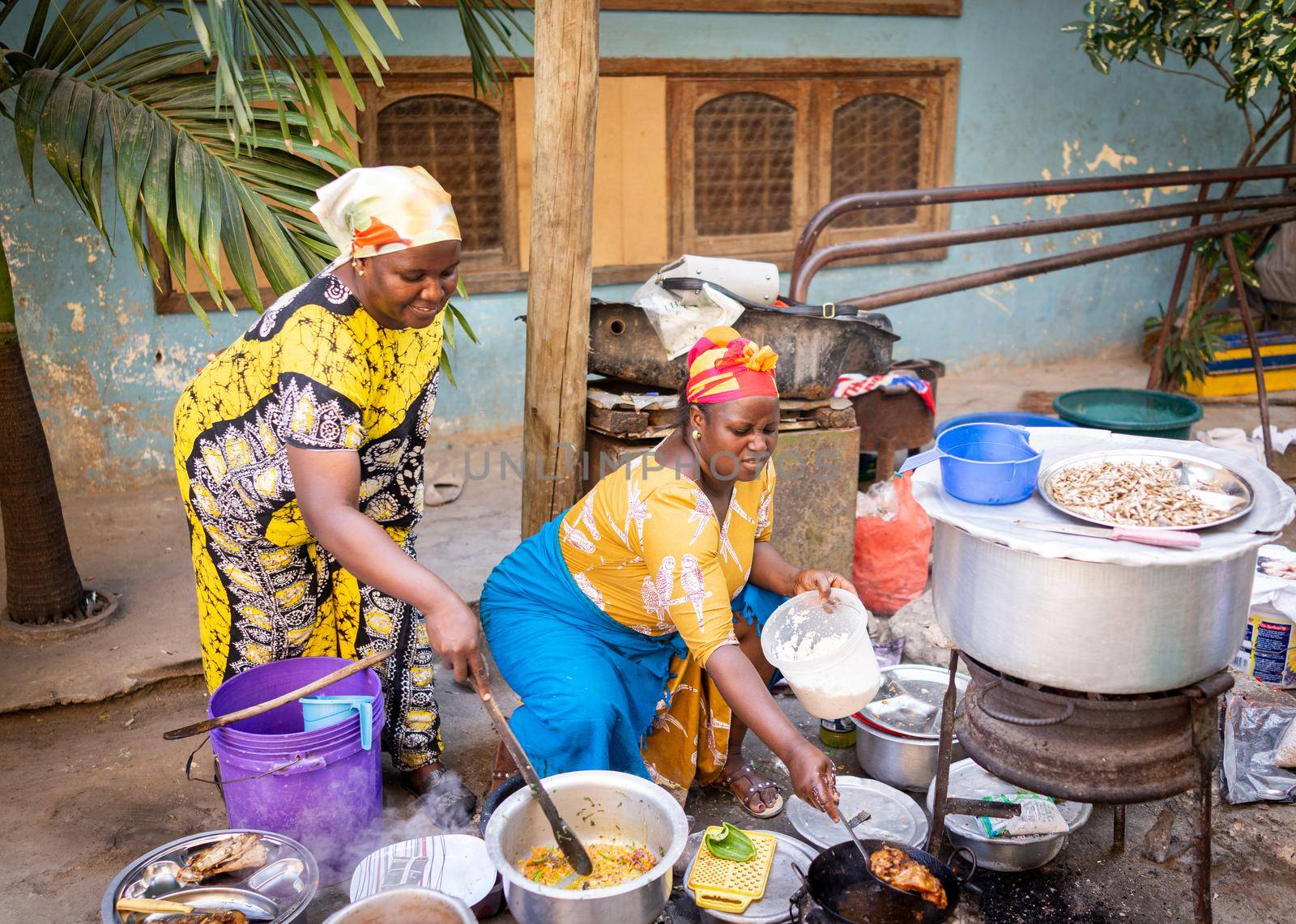 African woman cooking traditional food at street