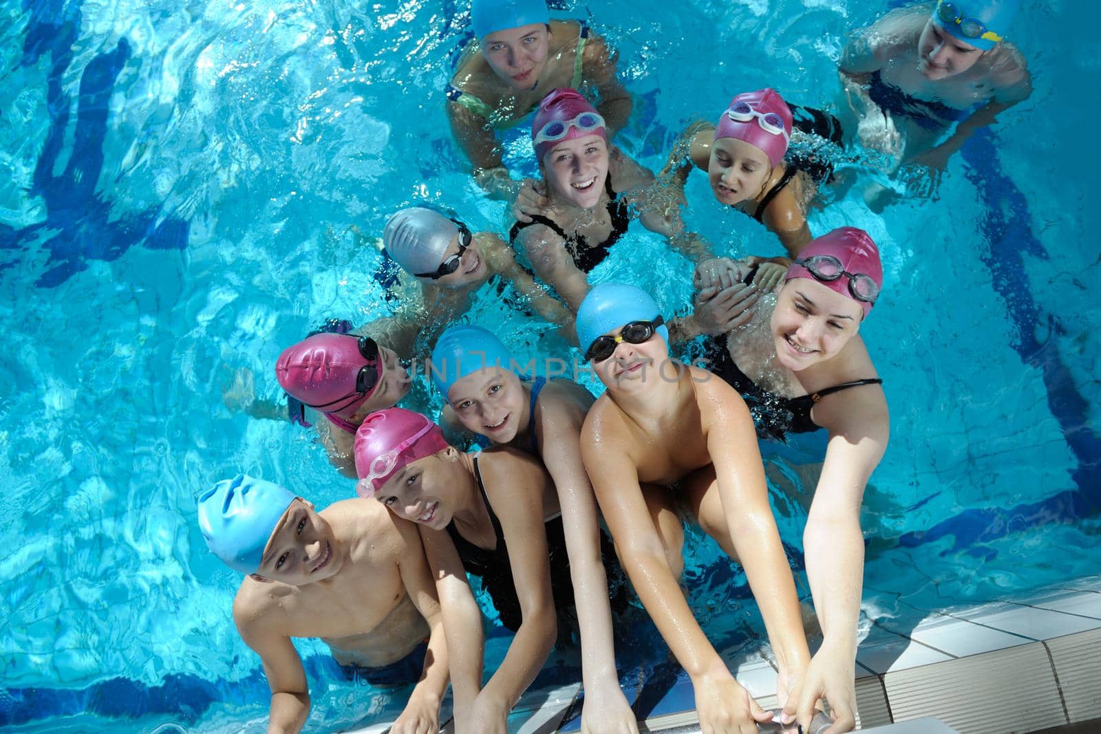 happy children kids group  at swimming pool class  learning to swim