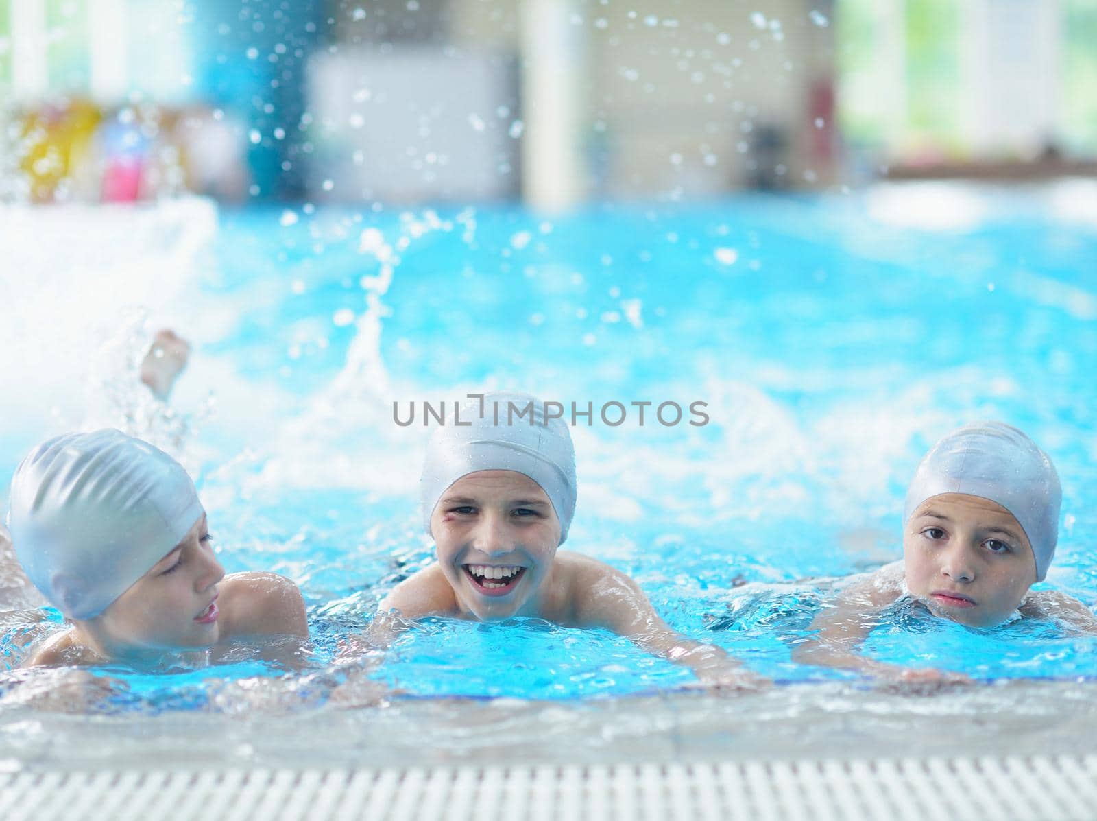 group of happy kids children   at swimming pool class  learning to swim