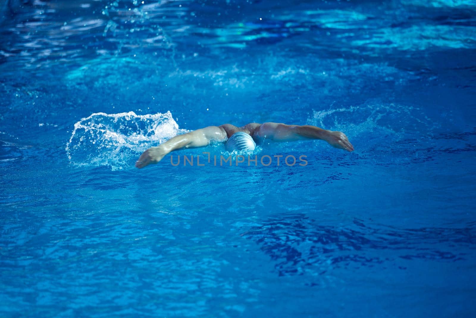 swimmer excercise on indoor swimming pool, sport and health concept