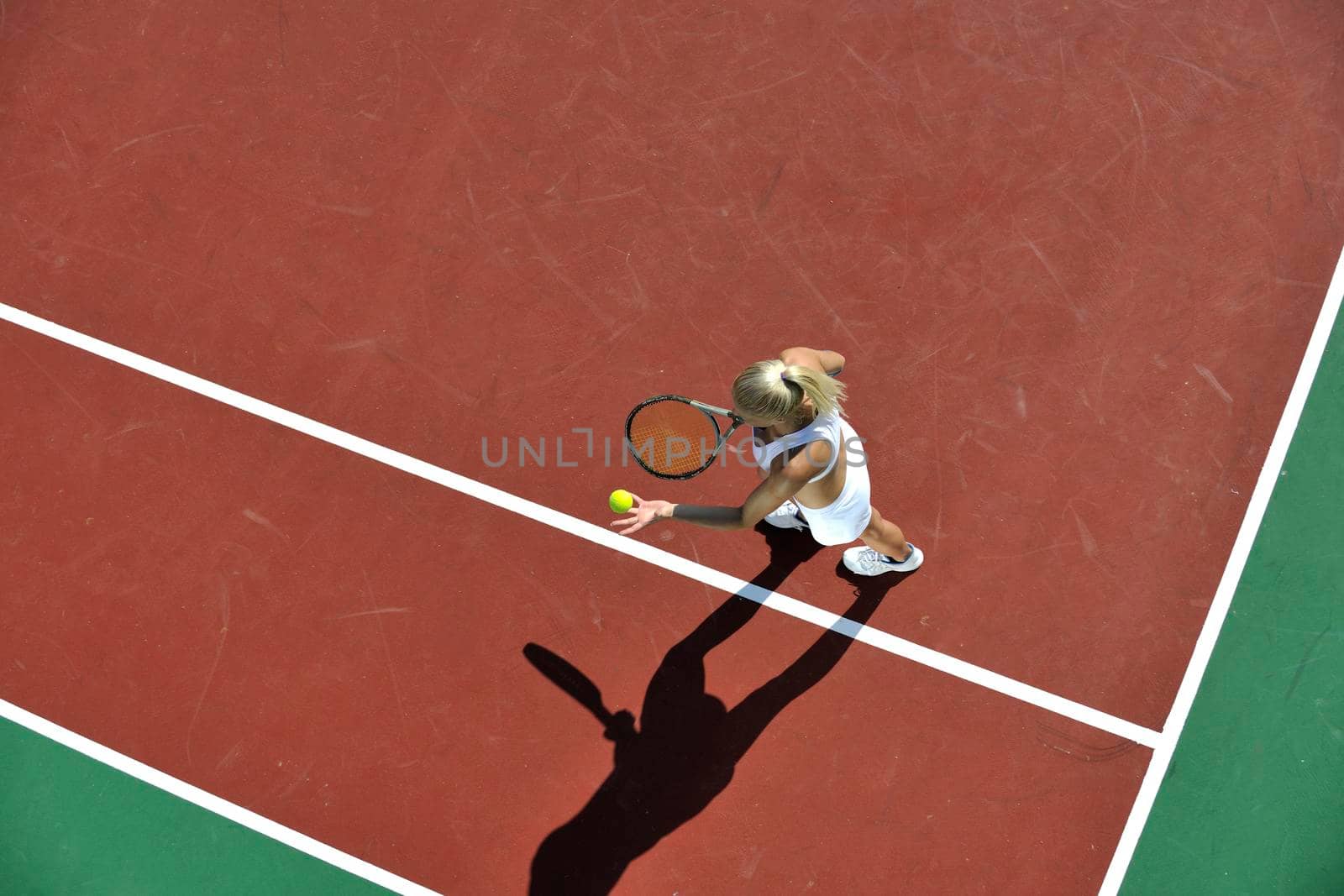 young woman play tennis outdoor by dotshock