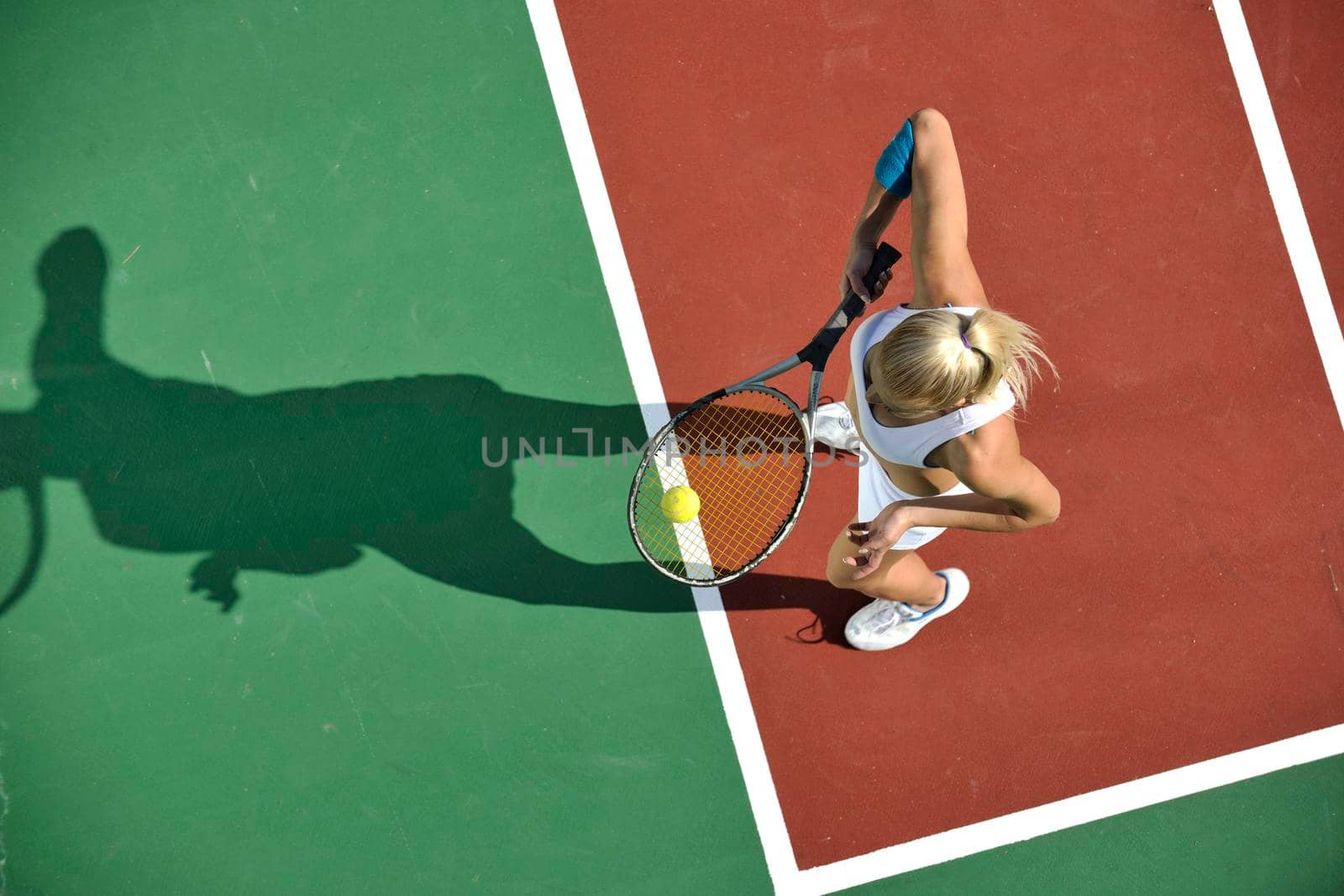 young woman play tennis outdoor by dotshock