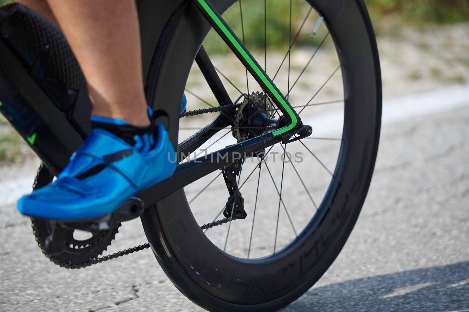 closeup of triathlon athlete riding bike by dotshock