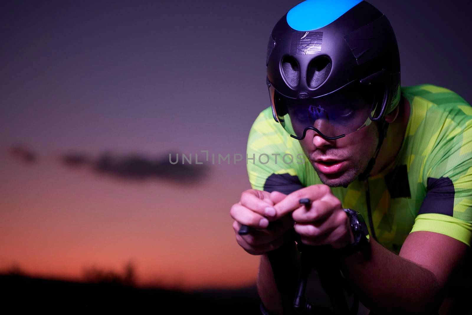 triathlon athlete riding bike fast  at night by dotshock