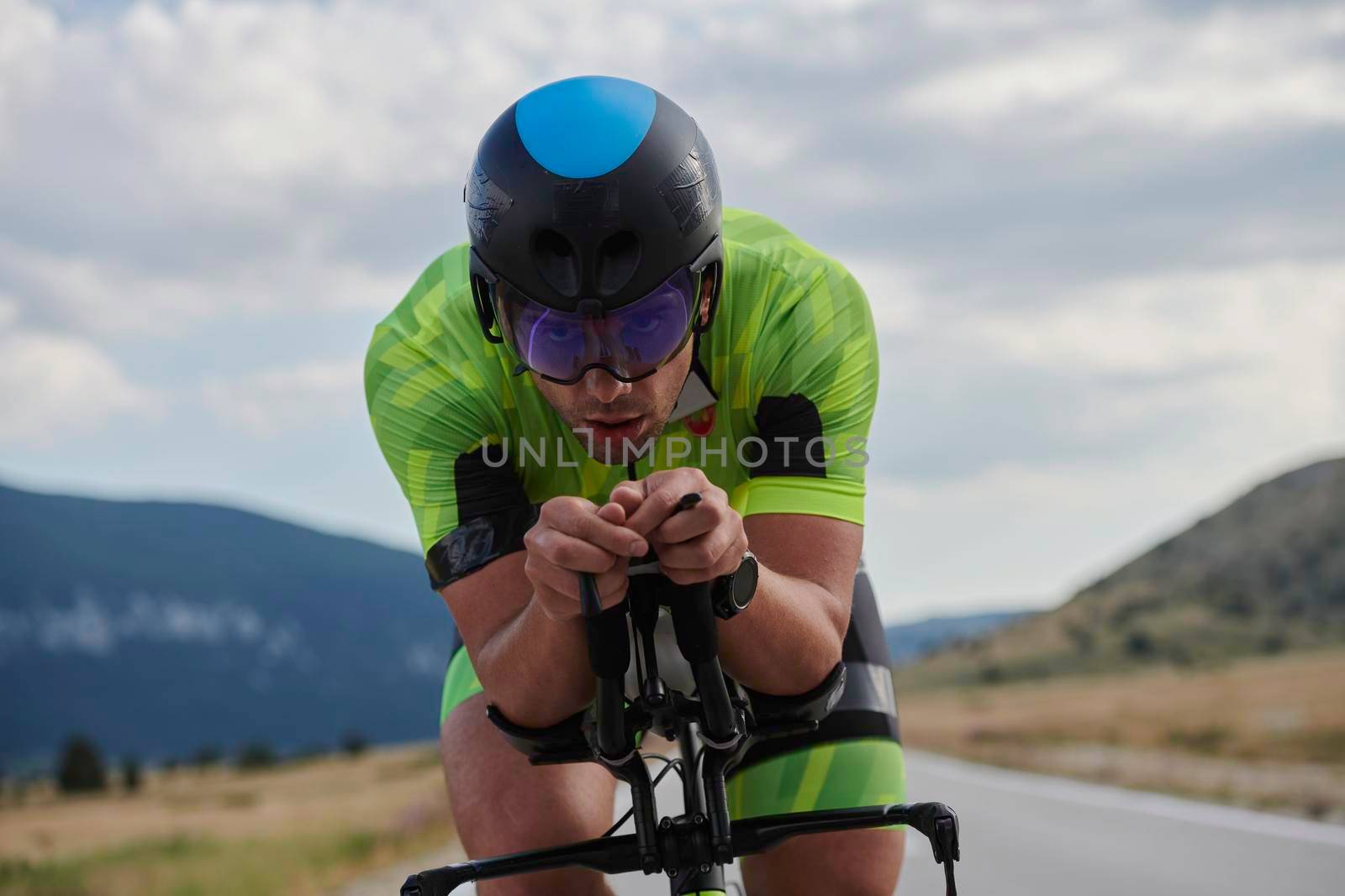 triathlon athlete riding professional racing bike at workout on curvy country road