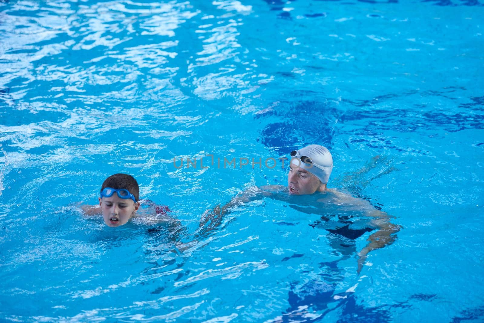 group of happy kids children   at swimming pool class  learning to swim