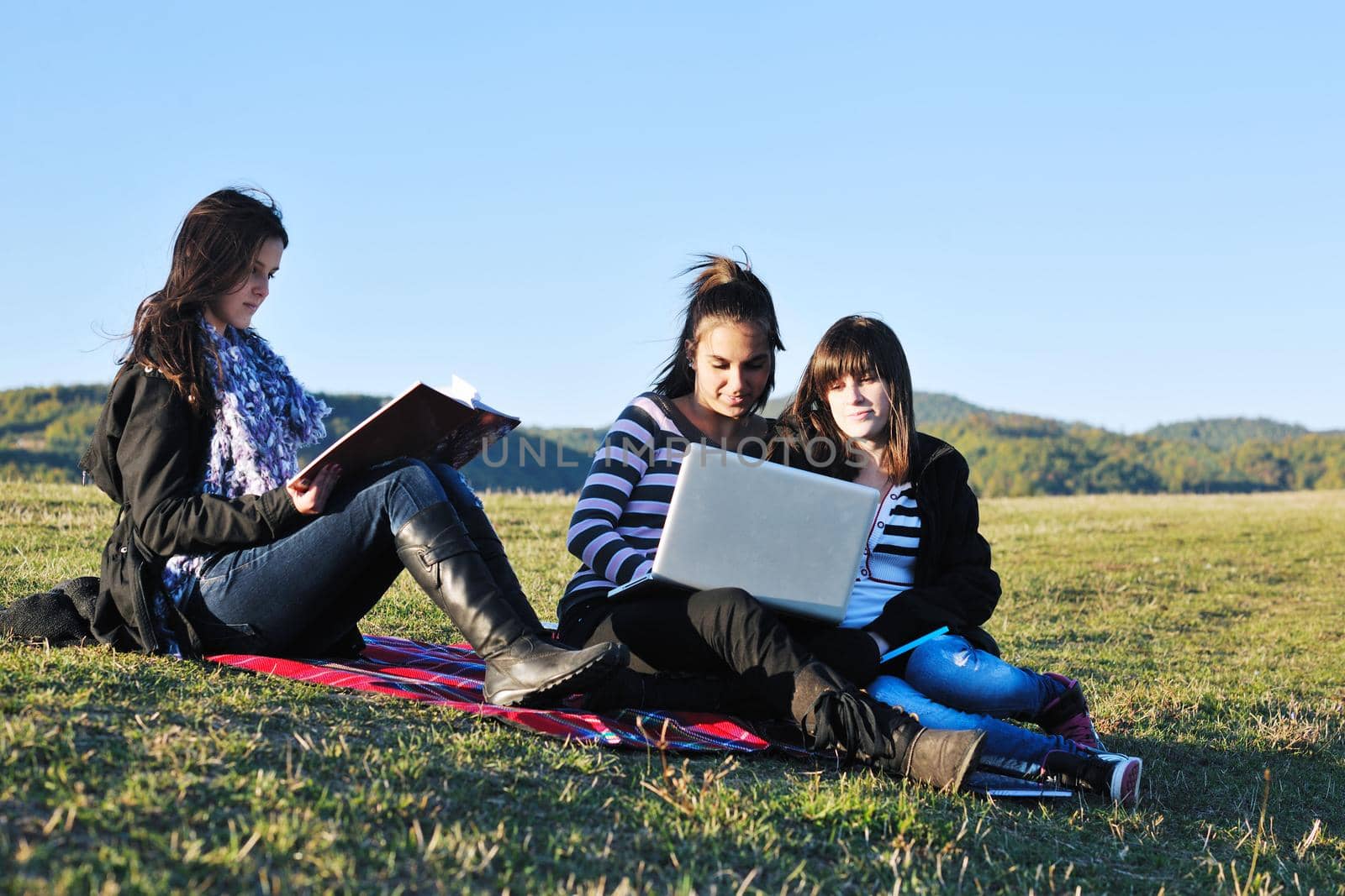 group of teen girl woman outdoor have fun and study homework on laptop computer