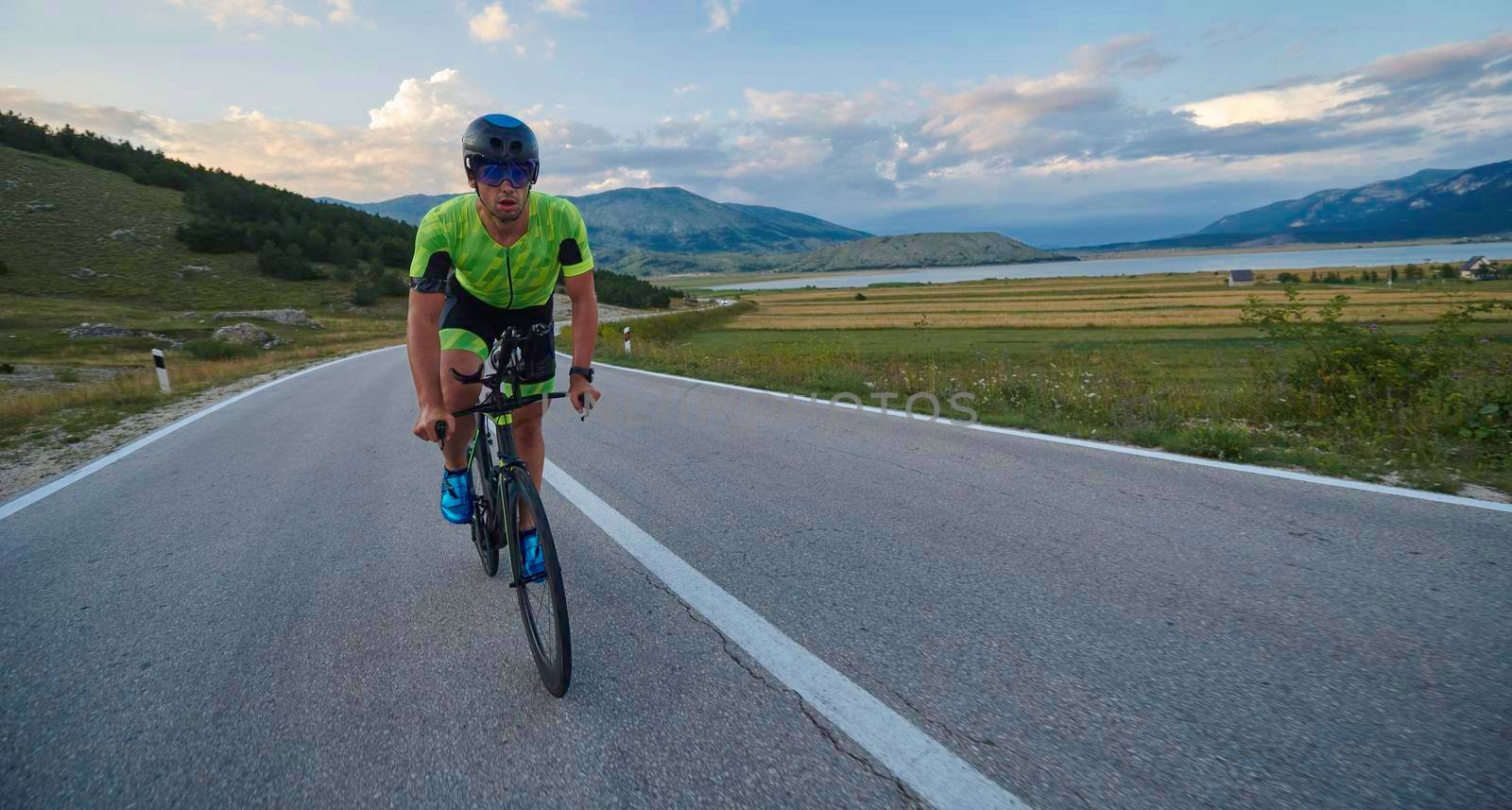 triathlon athlete riding professional racing bike at workout on curvy country road