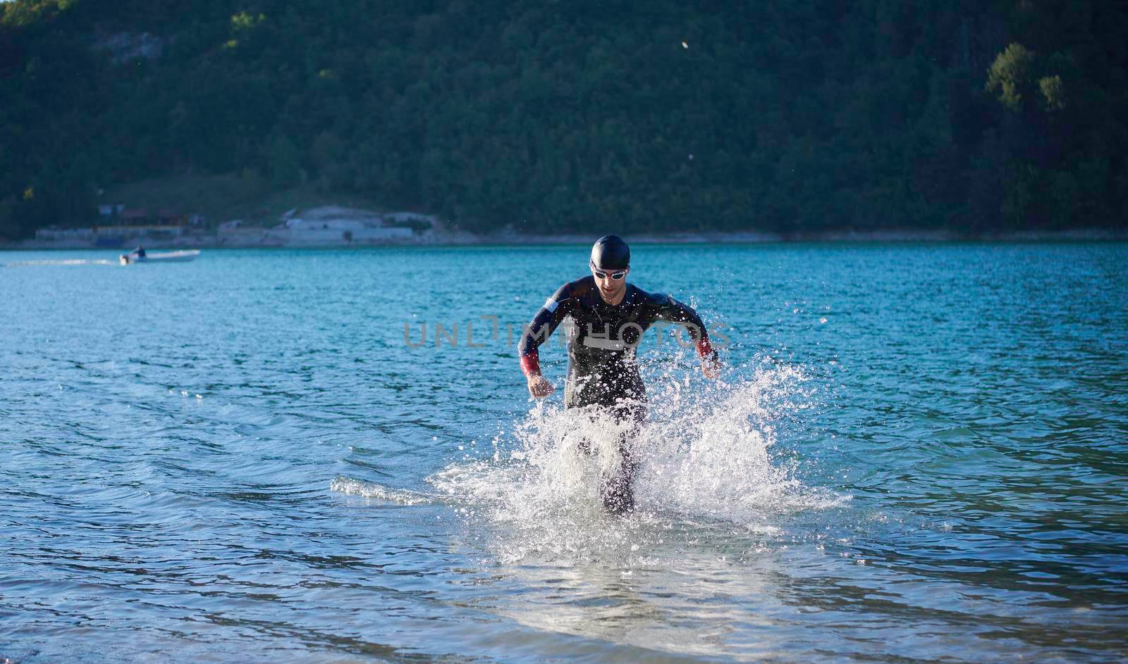 triathlon athlete start swimming training splashing water while running and jumping