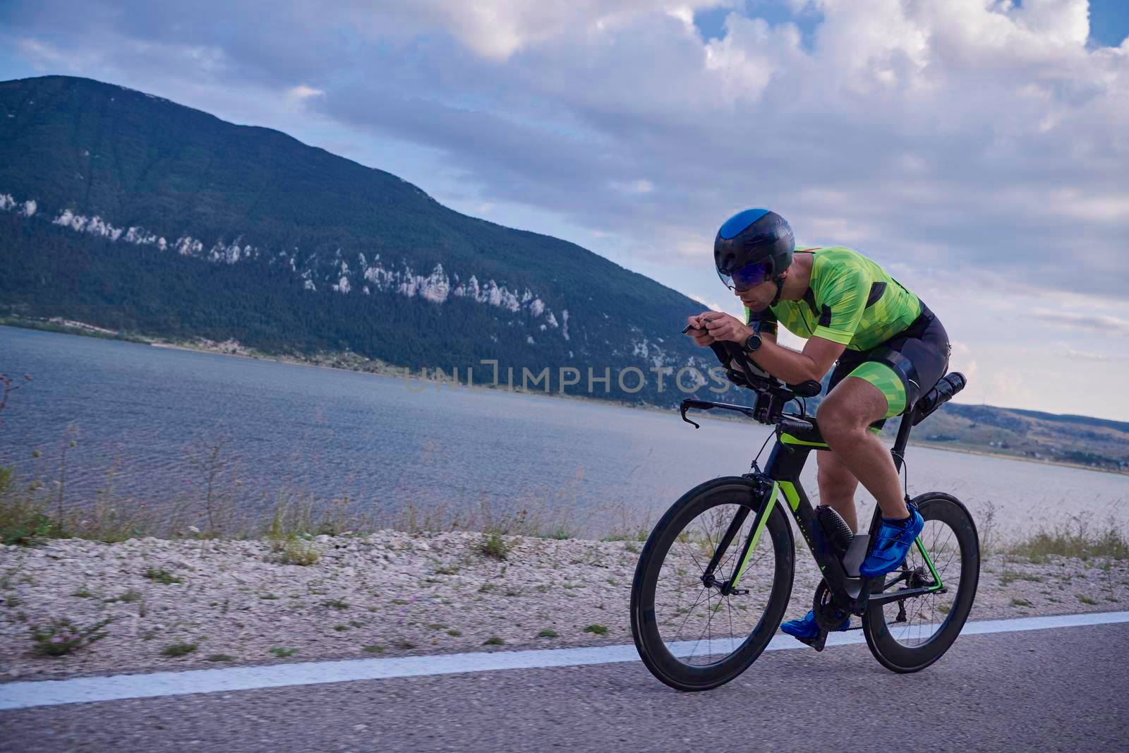 triathlon athlete riding professional racing bike at workout on curvy country road