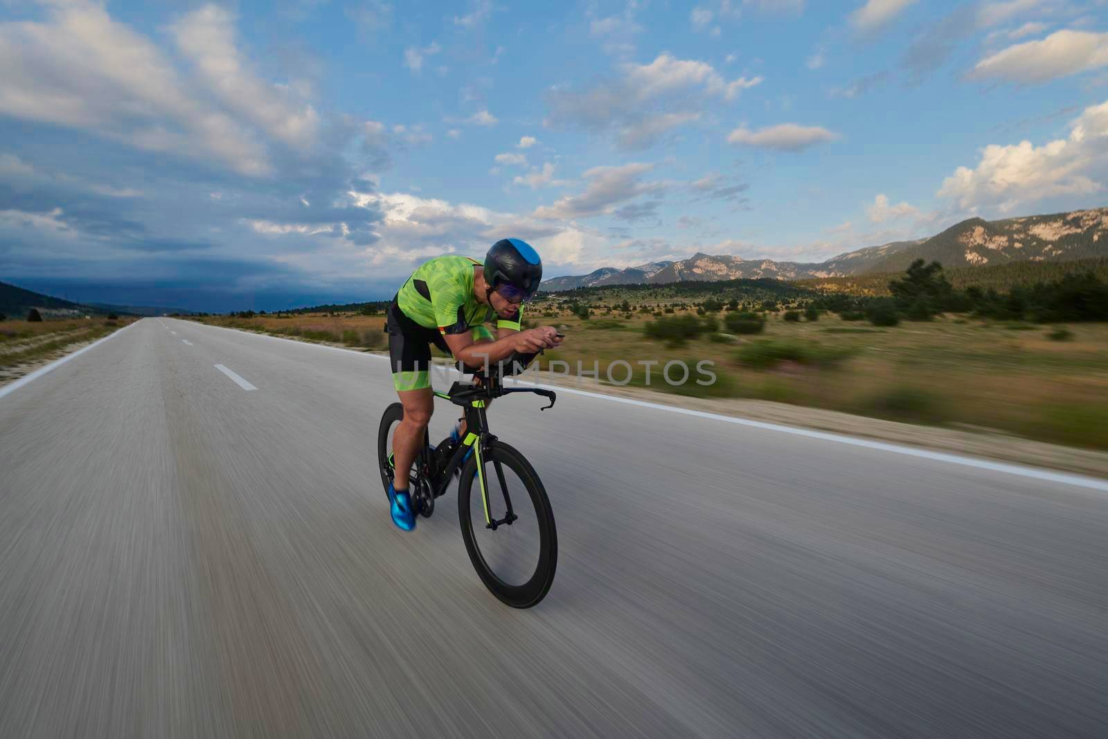 triathlon athlete riding professional racing bike at workout on curvy country road