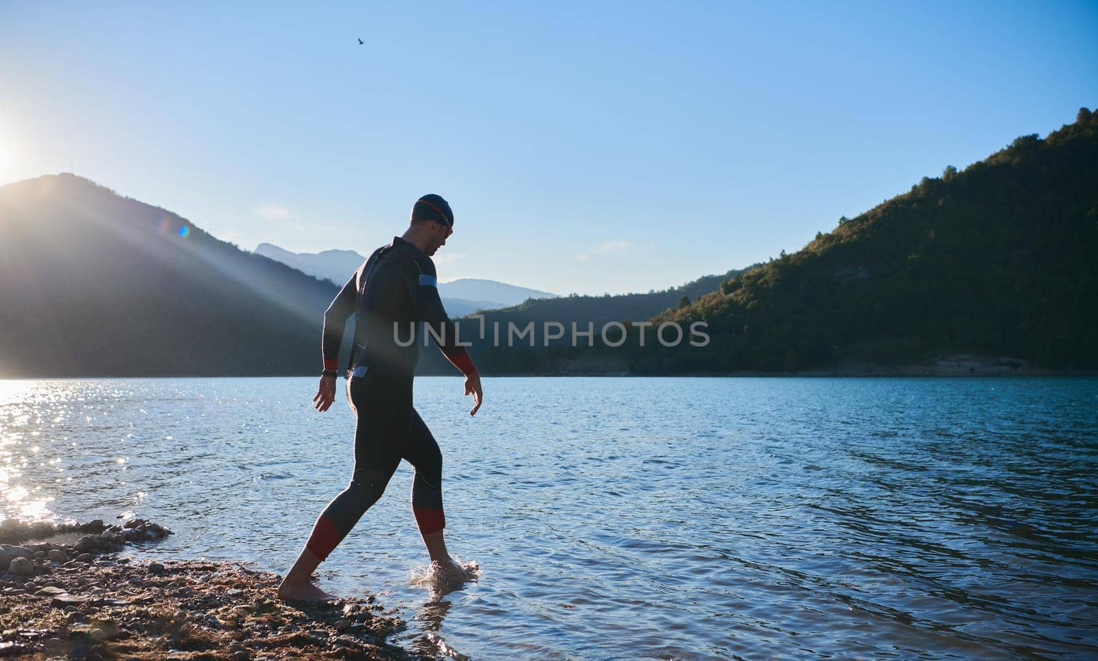 triathlon athlete start swimming training splashing water while running and jumping