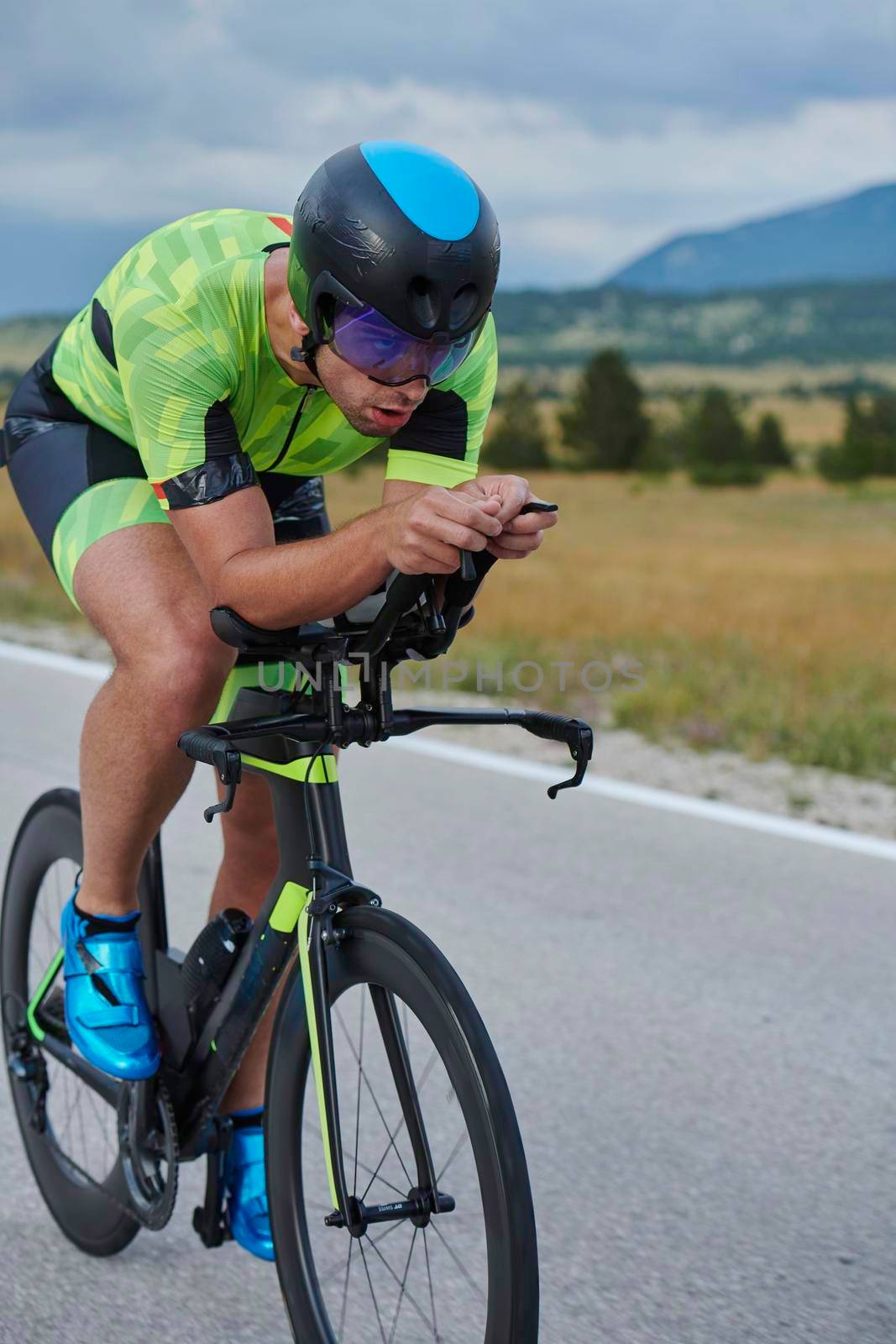 triathlon athlete riding professional racing bike at workout on curvy country road