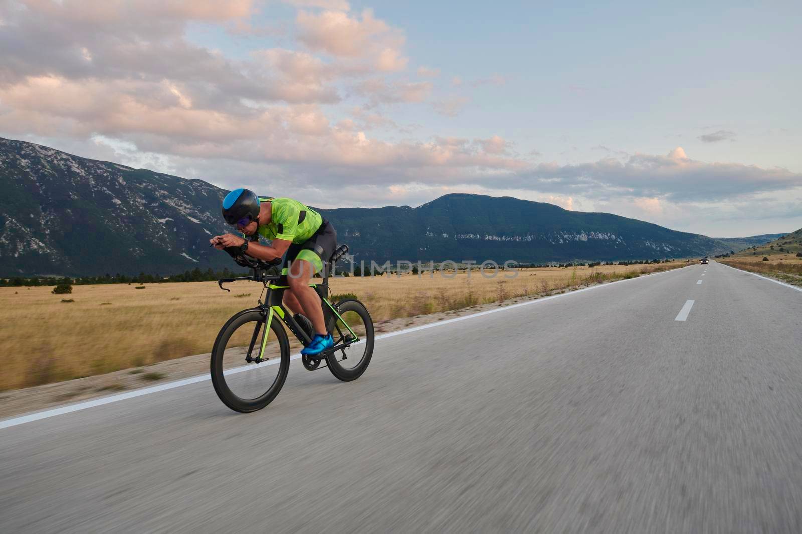 triathlon athlete riding professional racing bike at workout on curvy country road