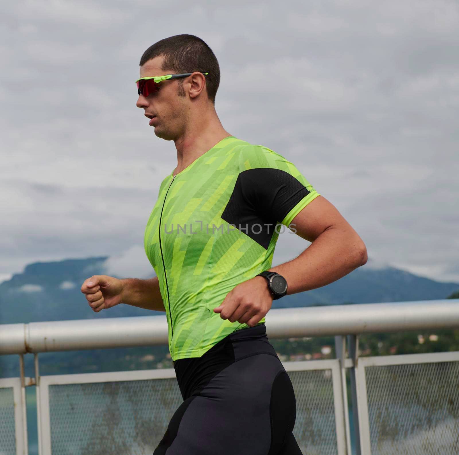 triathlon athlete running on street by dotshock