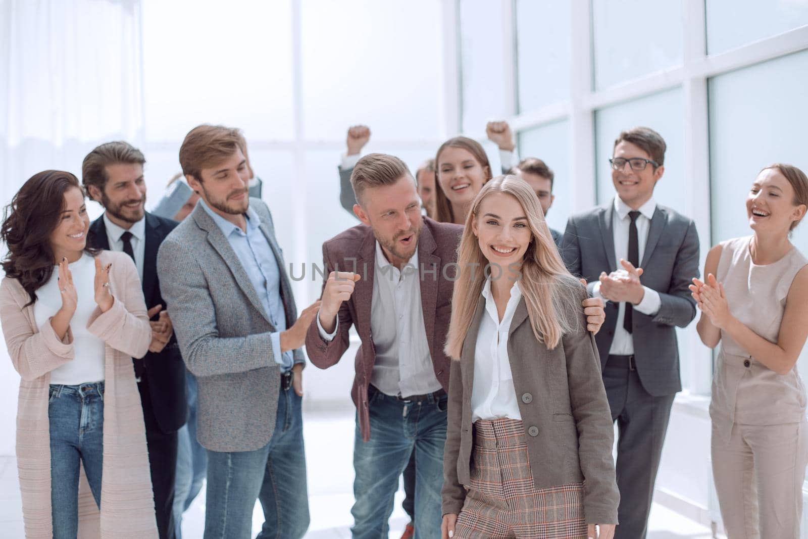 team of young people meeting their colleague with applause. by asdf