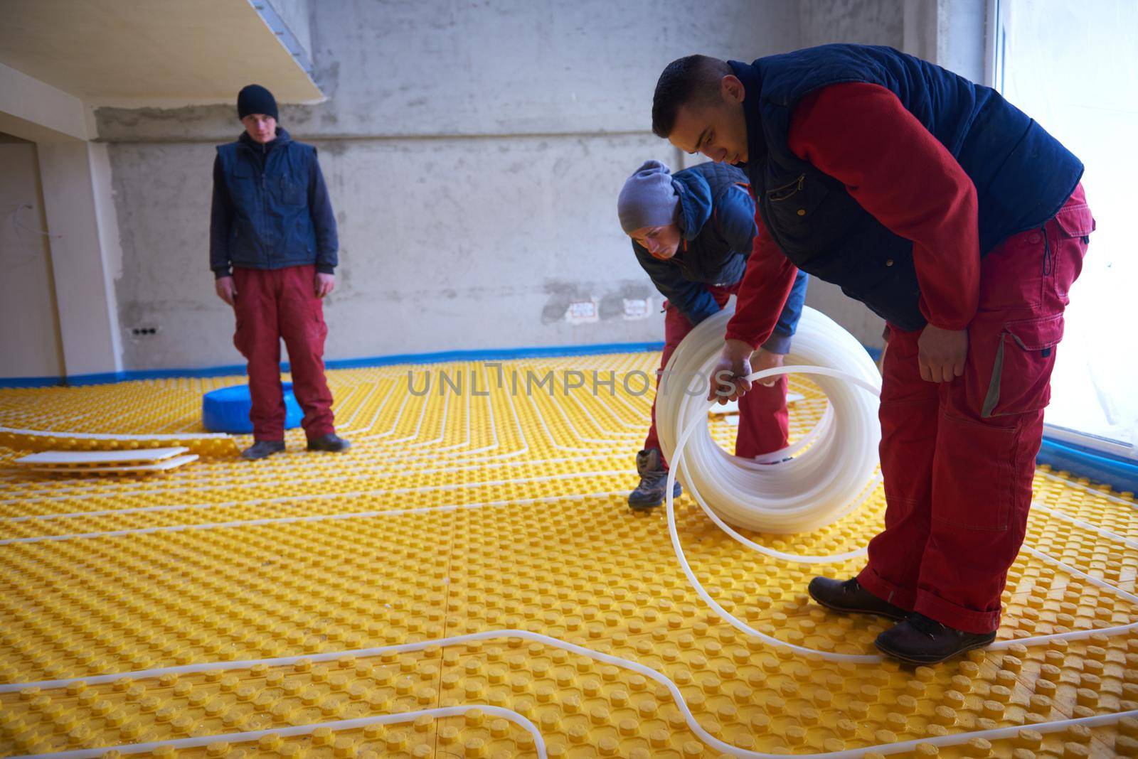 grouo of workera installing underfloor heating and colling in modern home