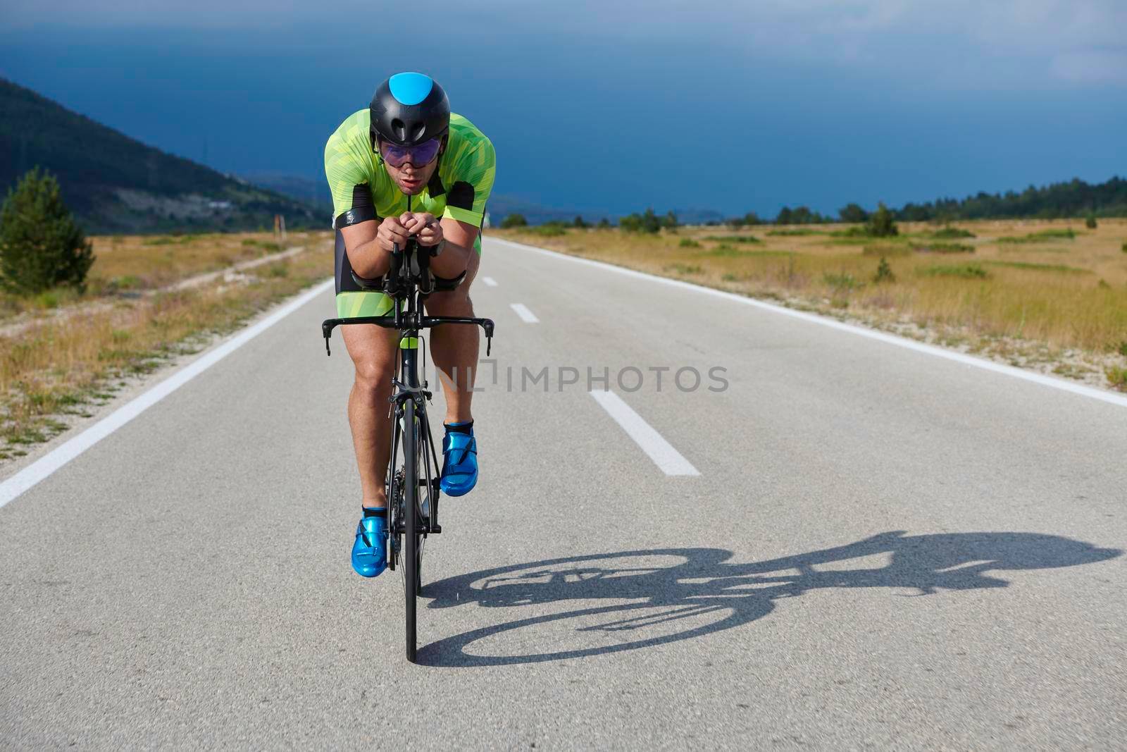 triathlon athlete riding professional racing bike at workout on curvy country road