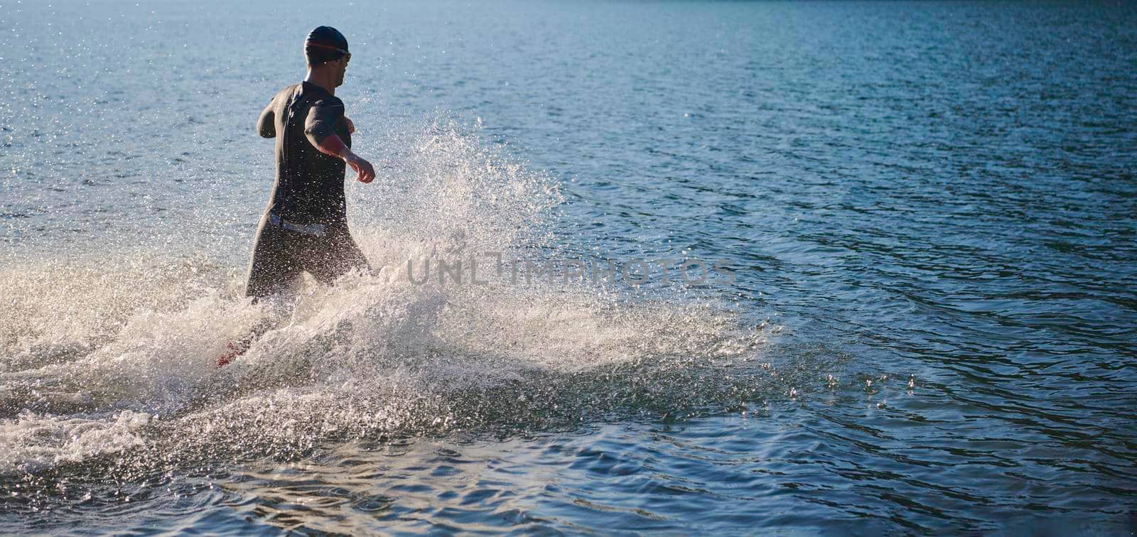 triathlon athlete start swimming training splashing water while running and jumping