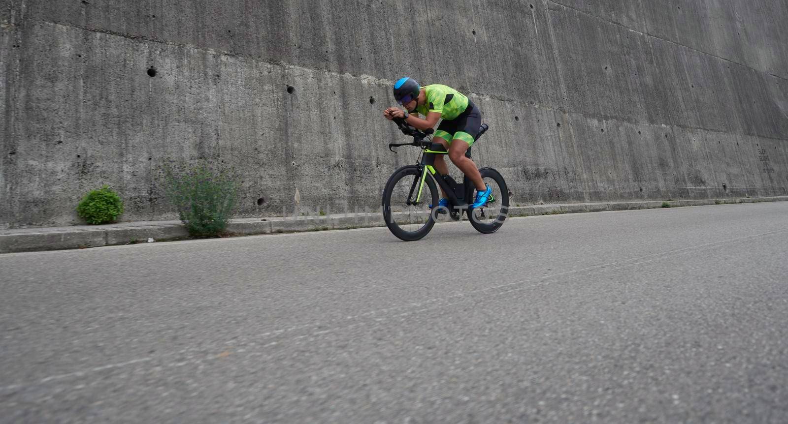 triathlon athlete riding racing bike on morning training urban enviroment