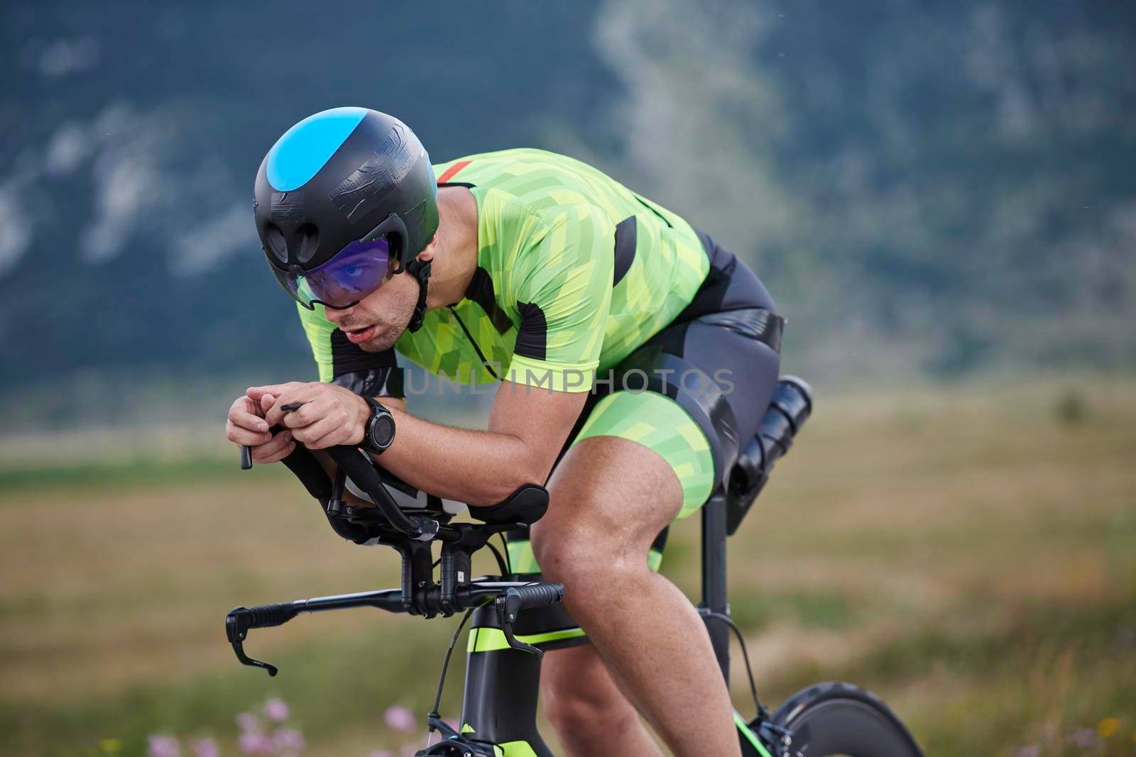 triathlon athlete riding professional racing bike at workout on curvy country road