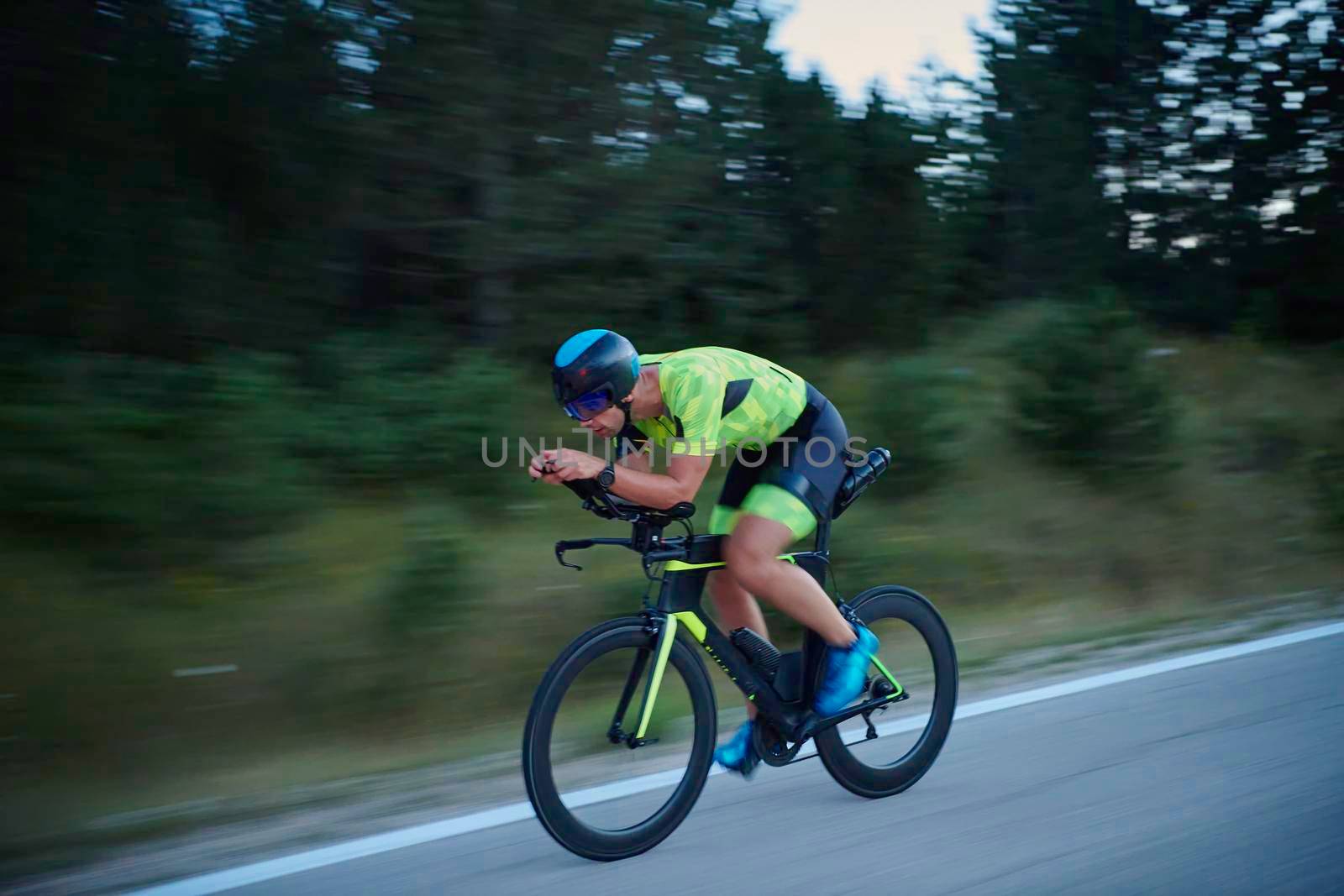 triathlon athlete riding bike at night by dotshock