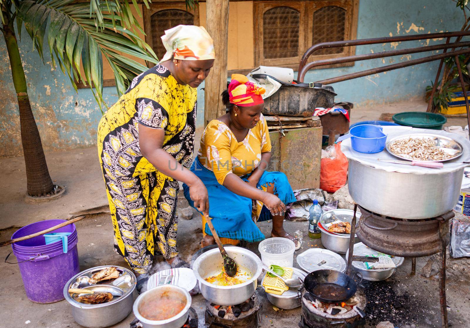 African woman cooking traditional food at street