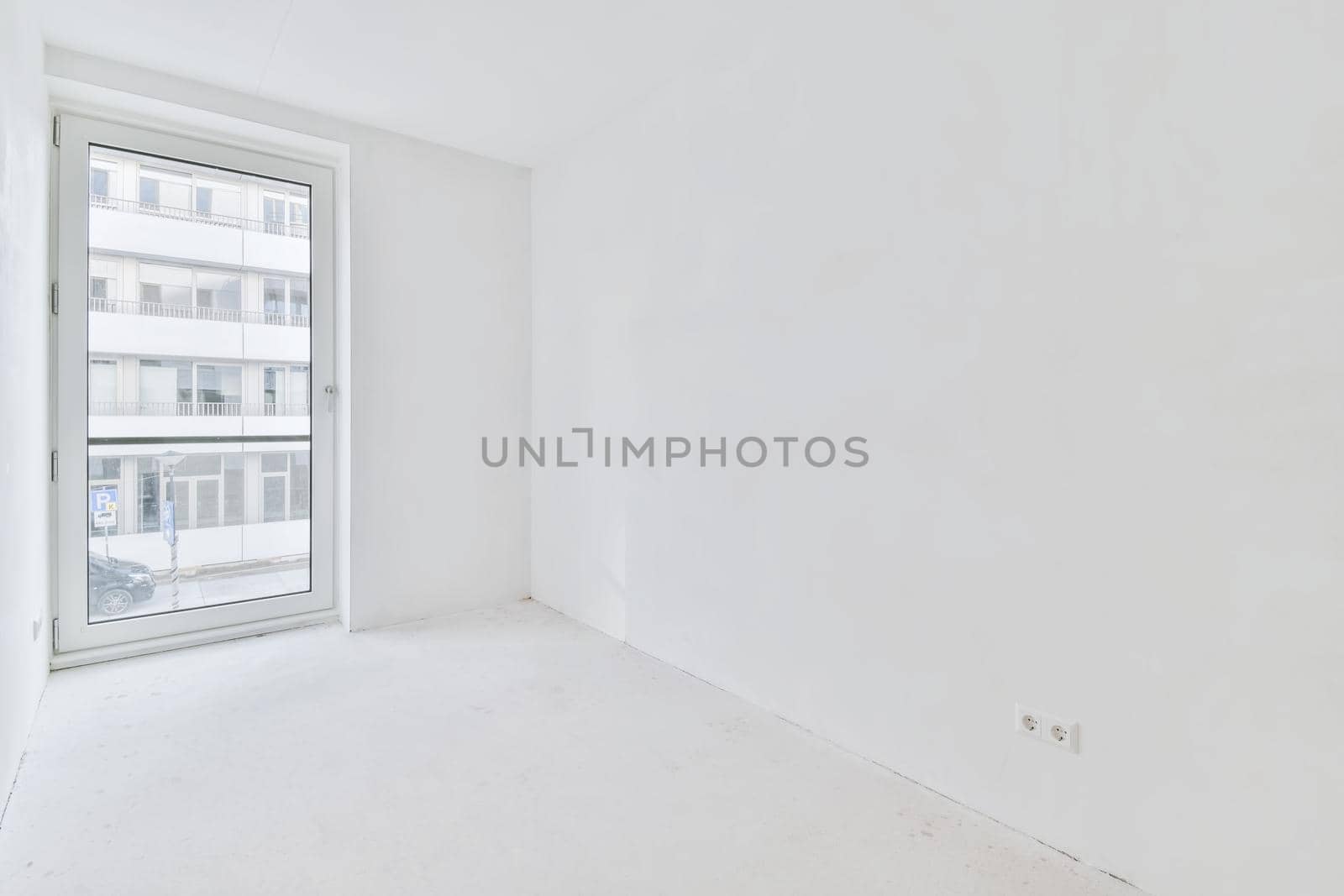 An absolutely white room with windows in an elegant apartment
