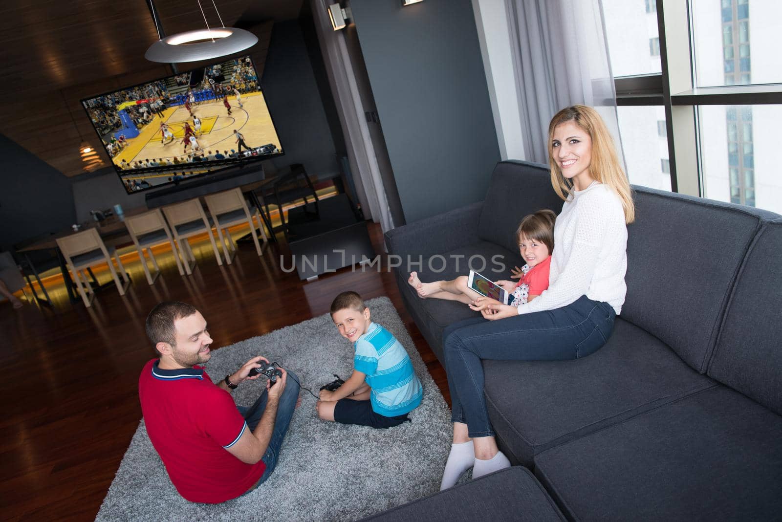 Happy family playing a basketball video game by dotshock