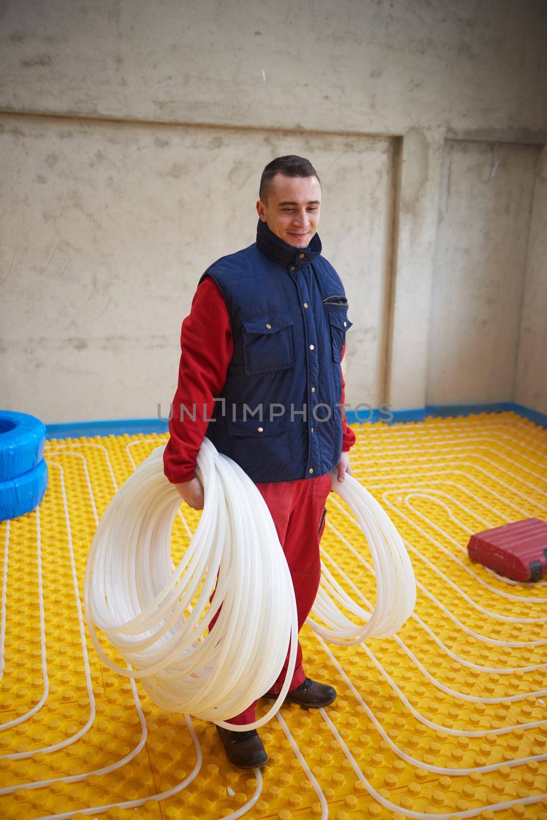 workers installing underfloor heating system by dotshock