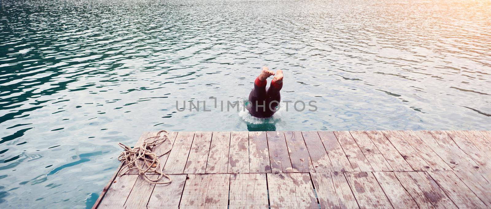 triathlon athlete jumping in water and starting with morning training on lake