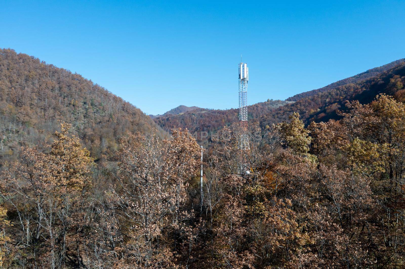 Telecommunications antenna tower in the morning. bright sunshine and blue sky with clouds. Transmitting antenna pairs. High quality photo