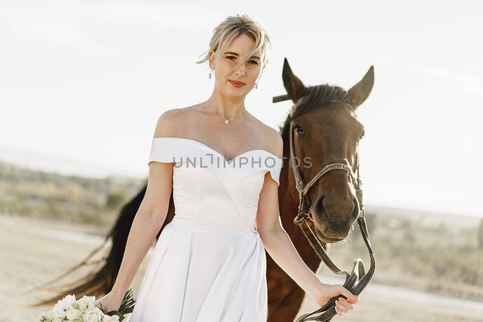 Portrait of a beautiful bride standing with horse