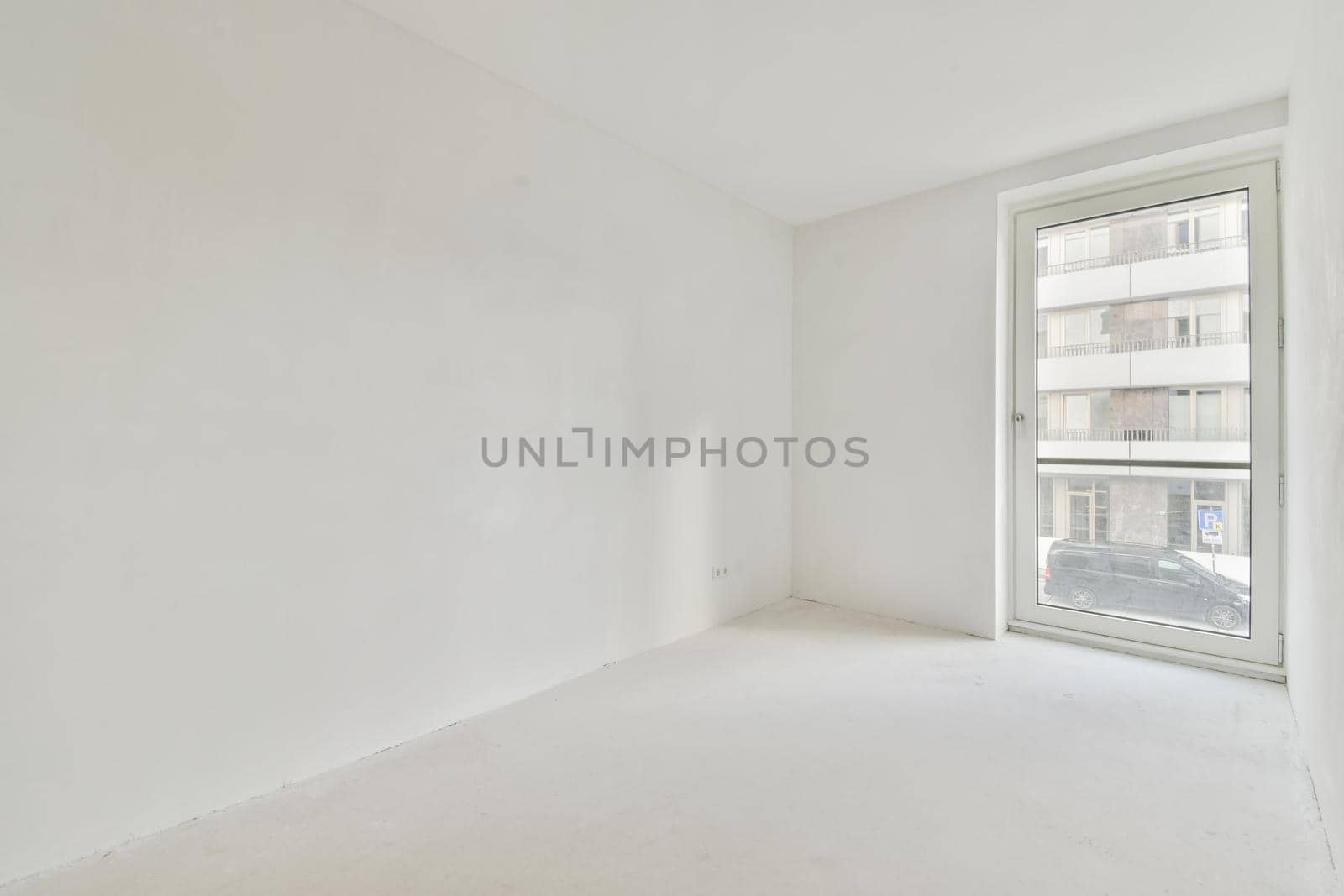 An absolutely white room with windows in an elegant apartment